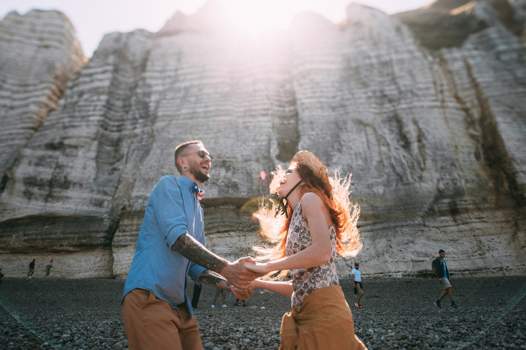 a couple holding hands in front of a rock formation