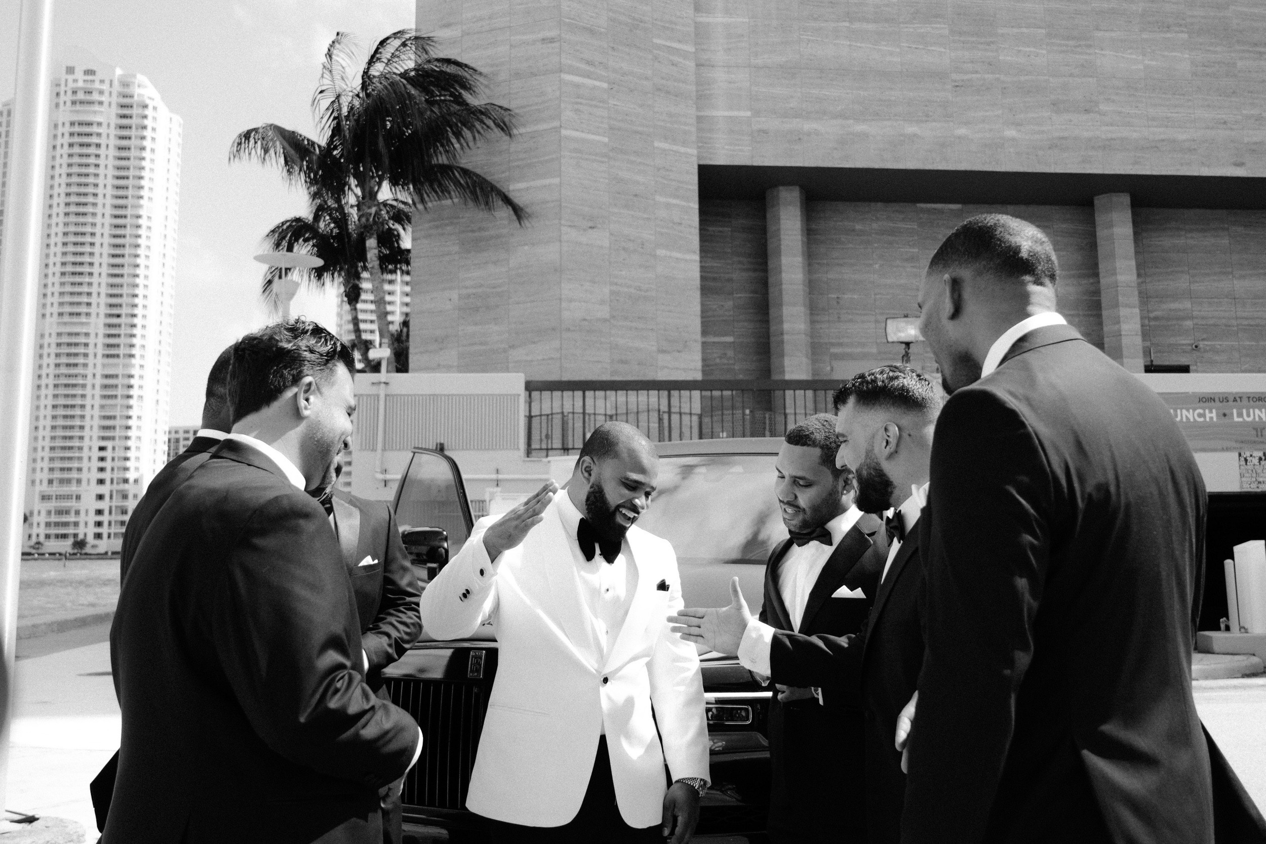 a group of men in suits and ties standing around a table