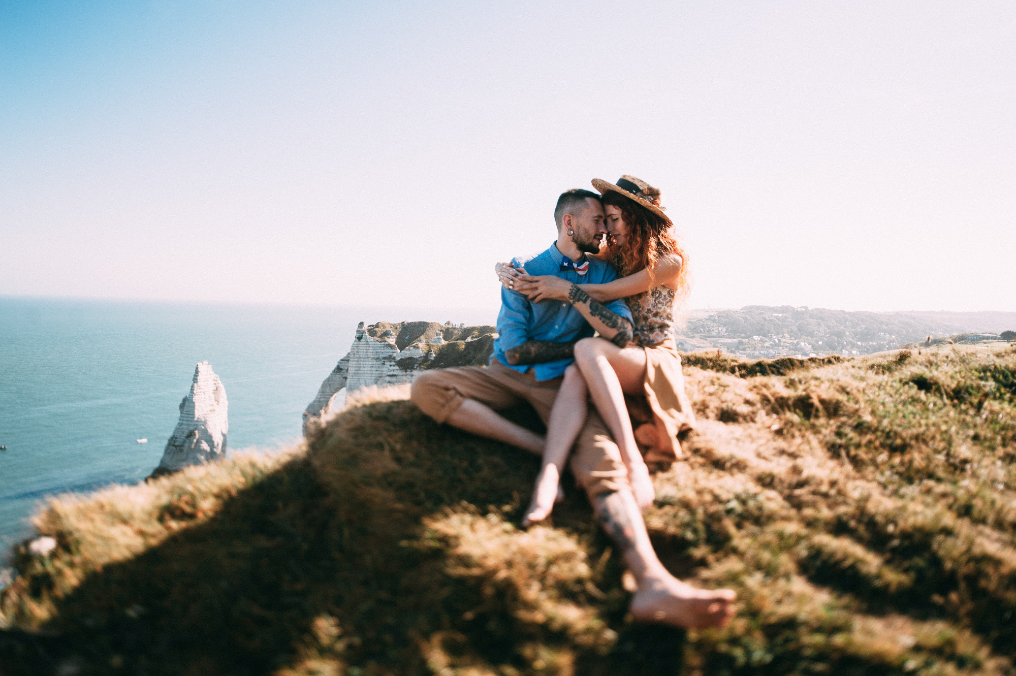 a man and woman sitting on a cliff