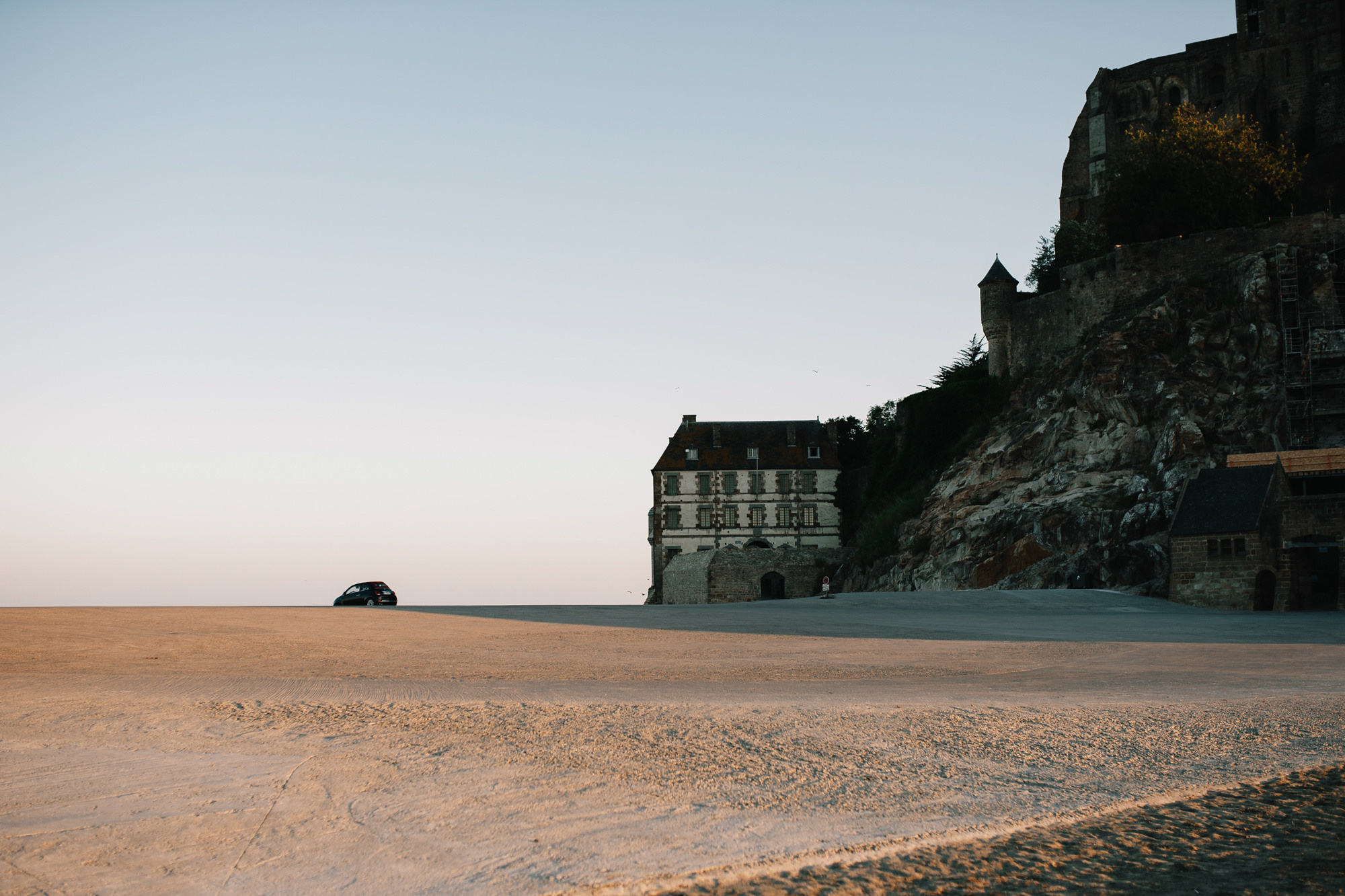 a car is parked in front of a cliff