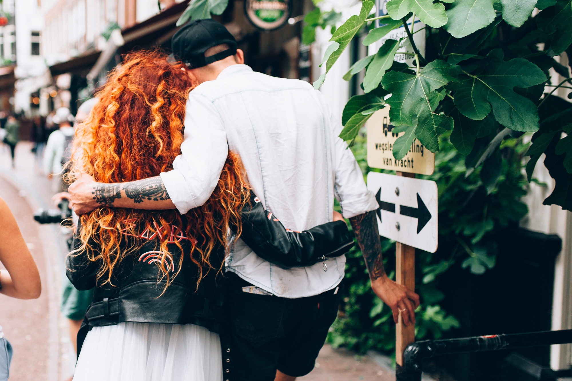 a woman with red hair walking down a street