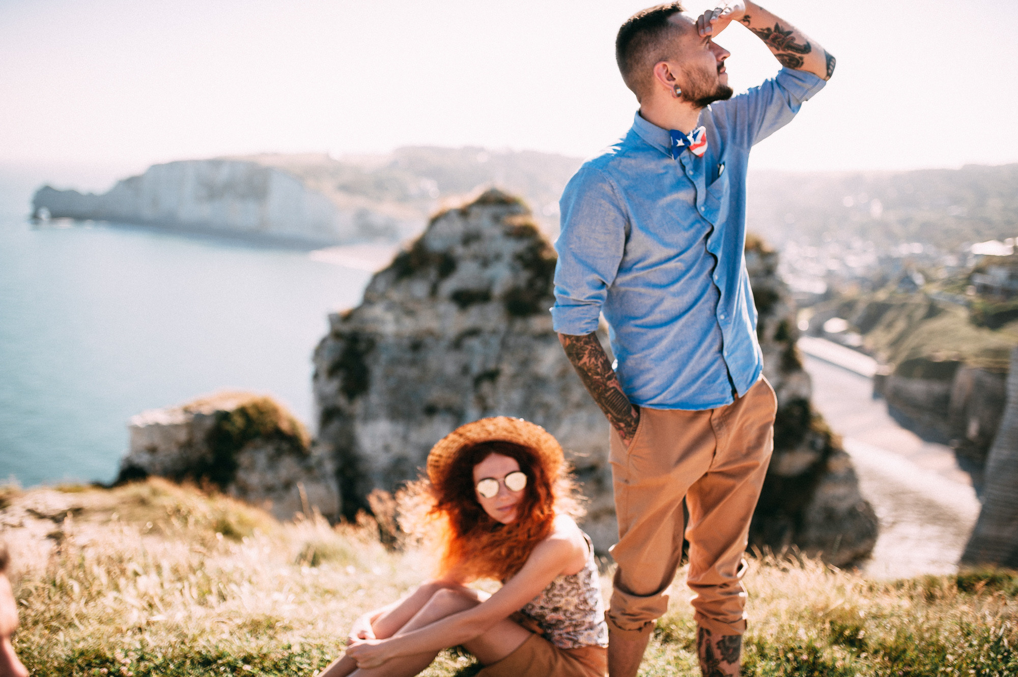 a man and woman sitting on a hill