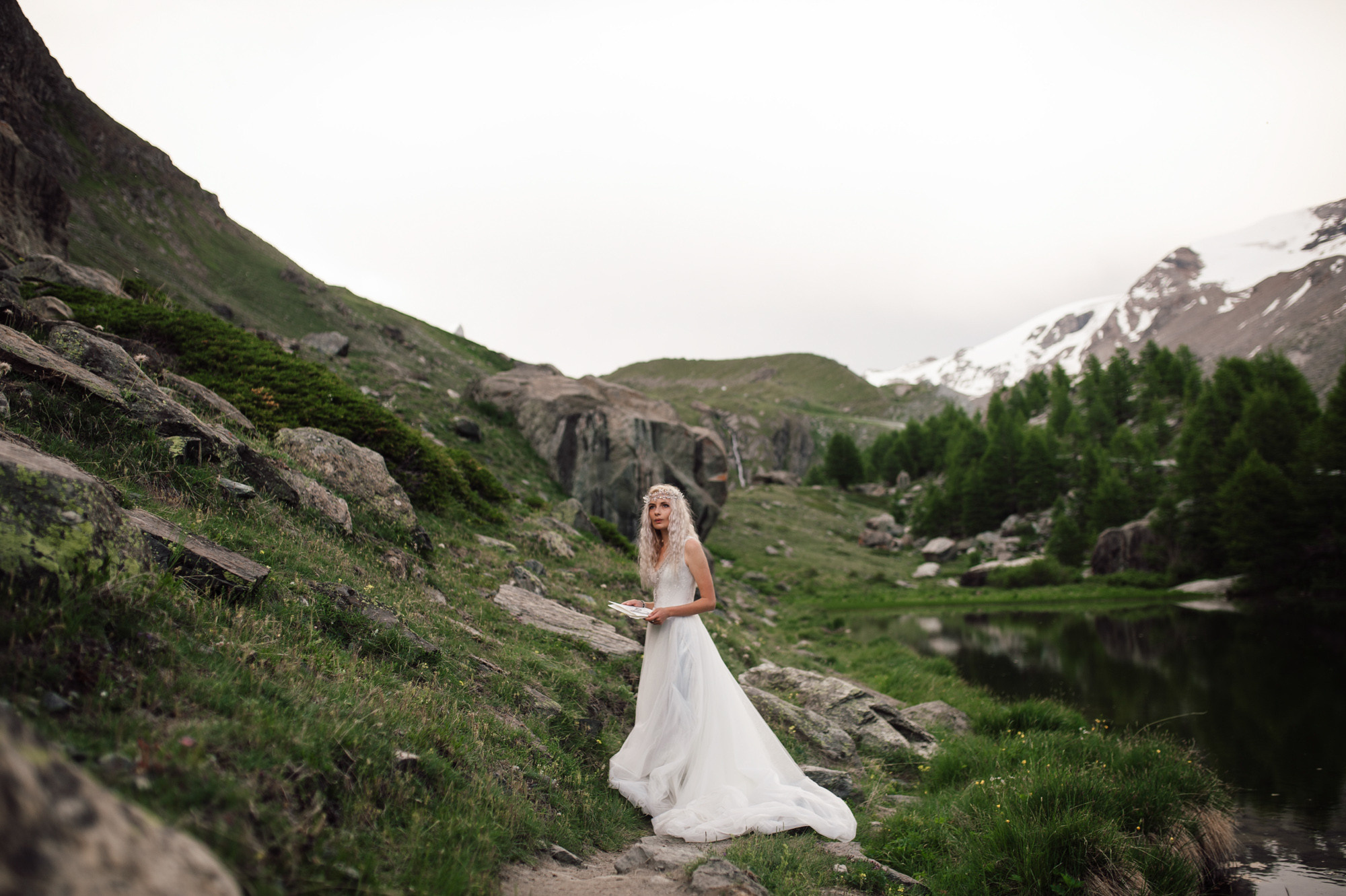 a bride standing on a rocky mountain path