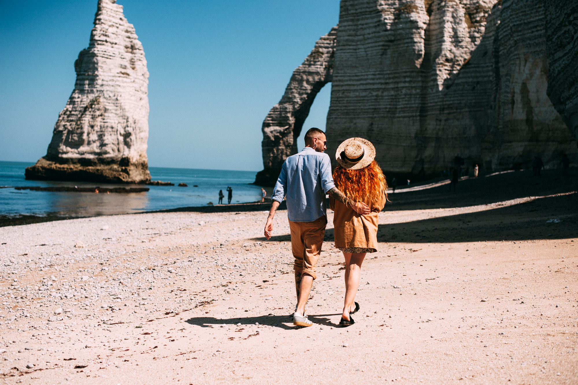 a man and woman walking on a beach