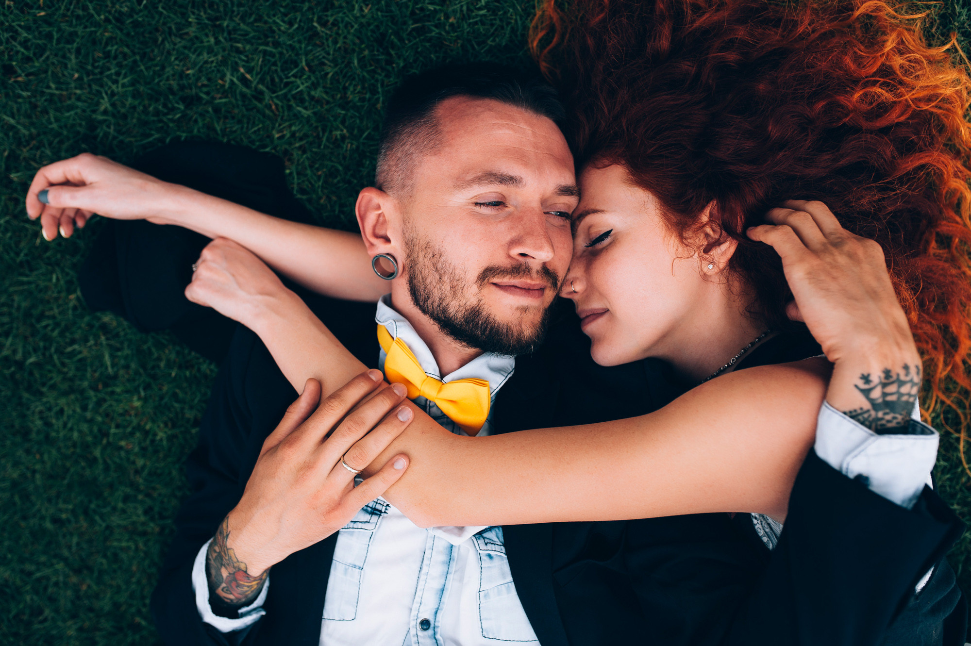 a man and woman laying on the grass