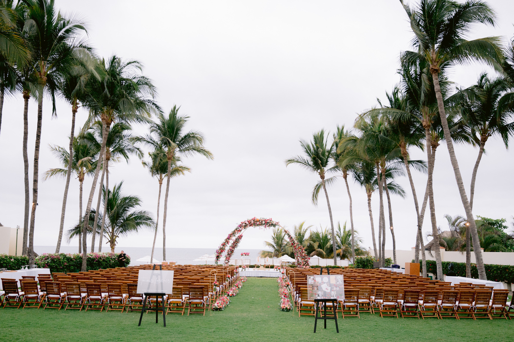 a wedding ceremony setup with chairs and palm trees