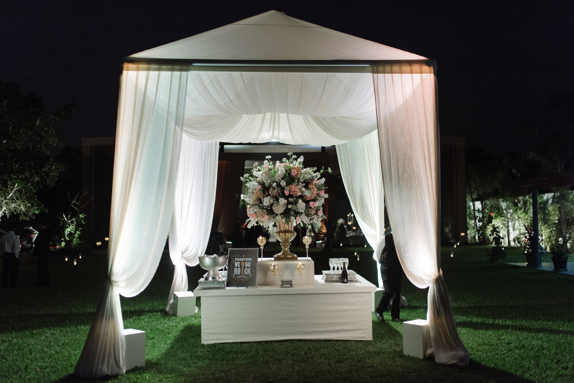 a wedding ceremony with a white canopy and flowers