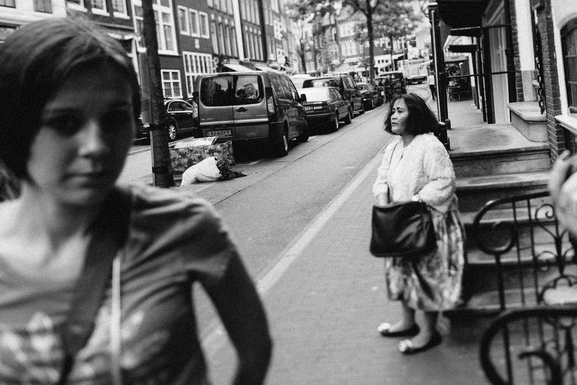 a woman sitting on a bench in a street