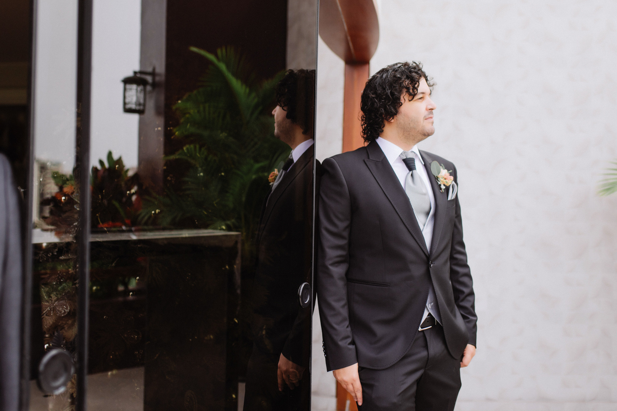 a man in a suit and tie standing in front of a mirror