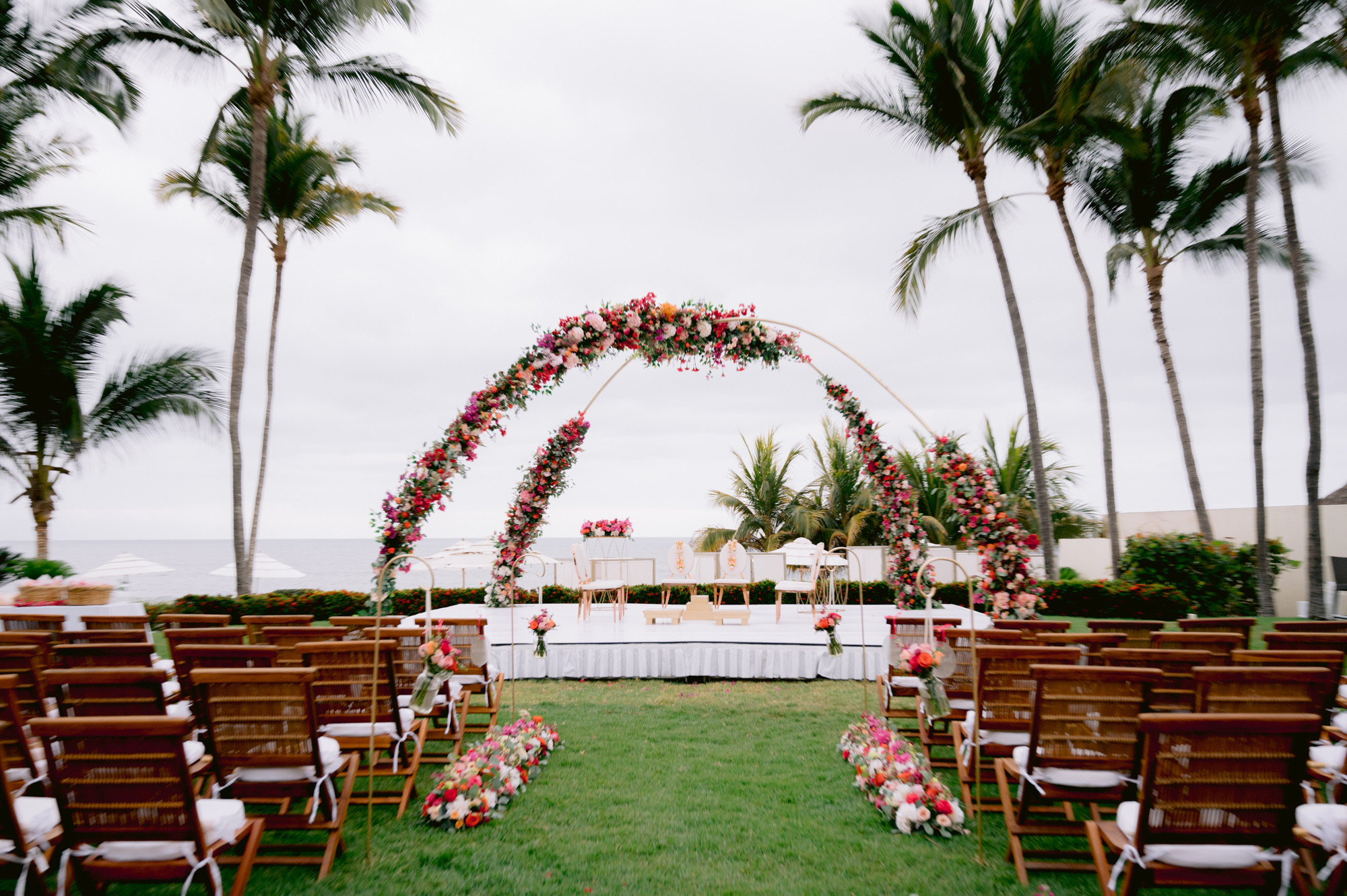 a wedding ceremony with a floral arch and chairs