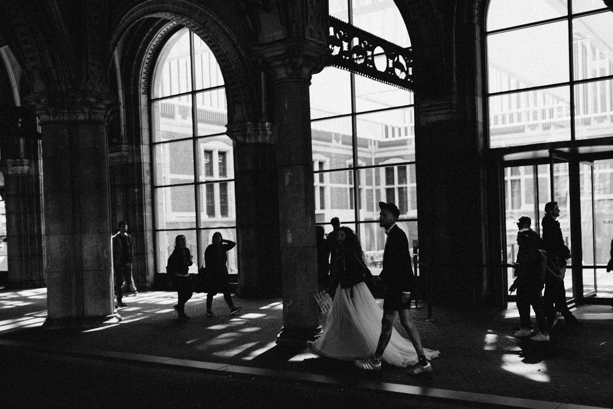 a bride and groom walking through the lobby of the old building