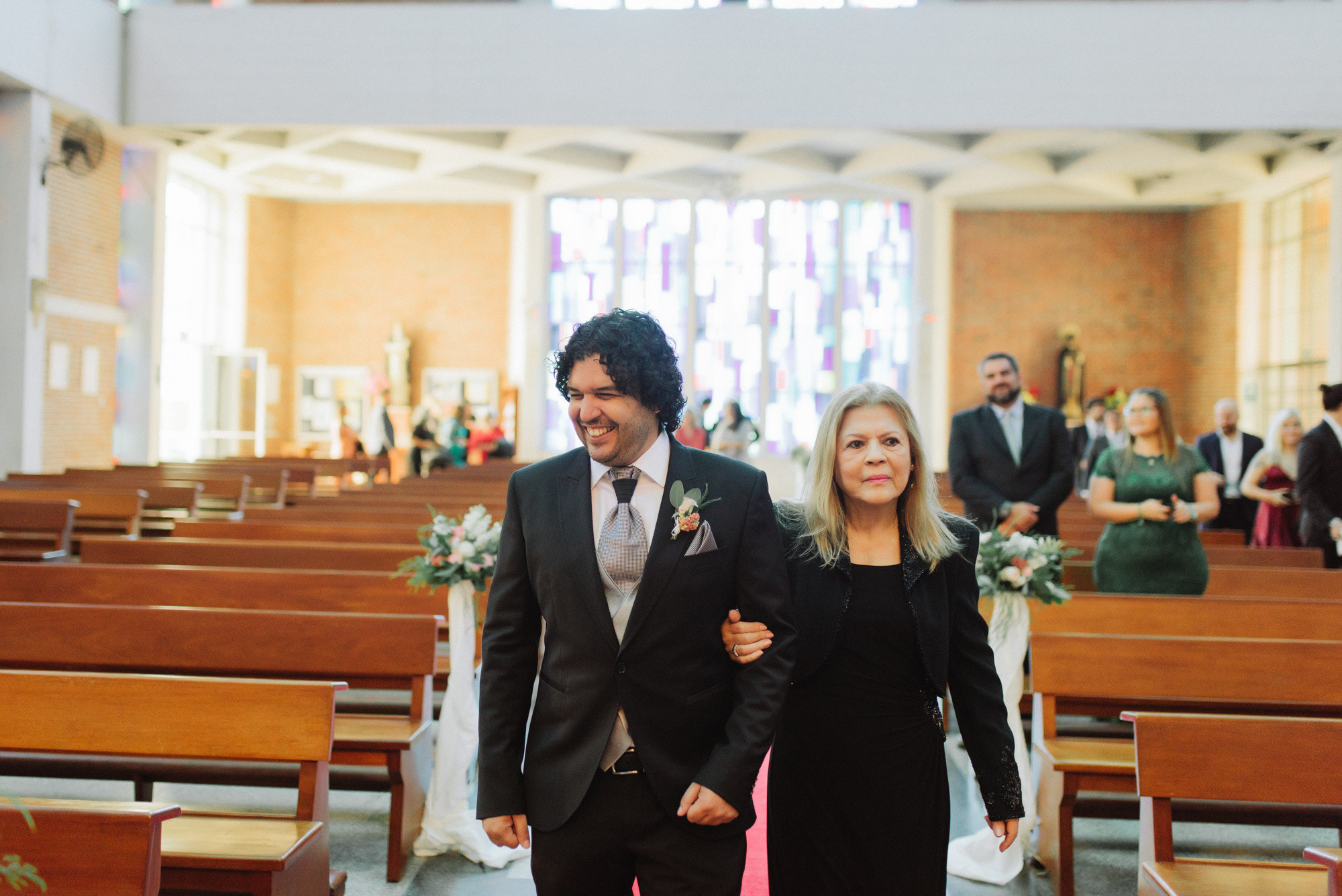 a man and woman walking down a church aisle