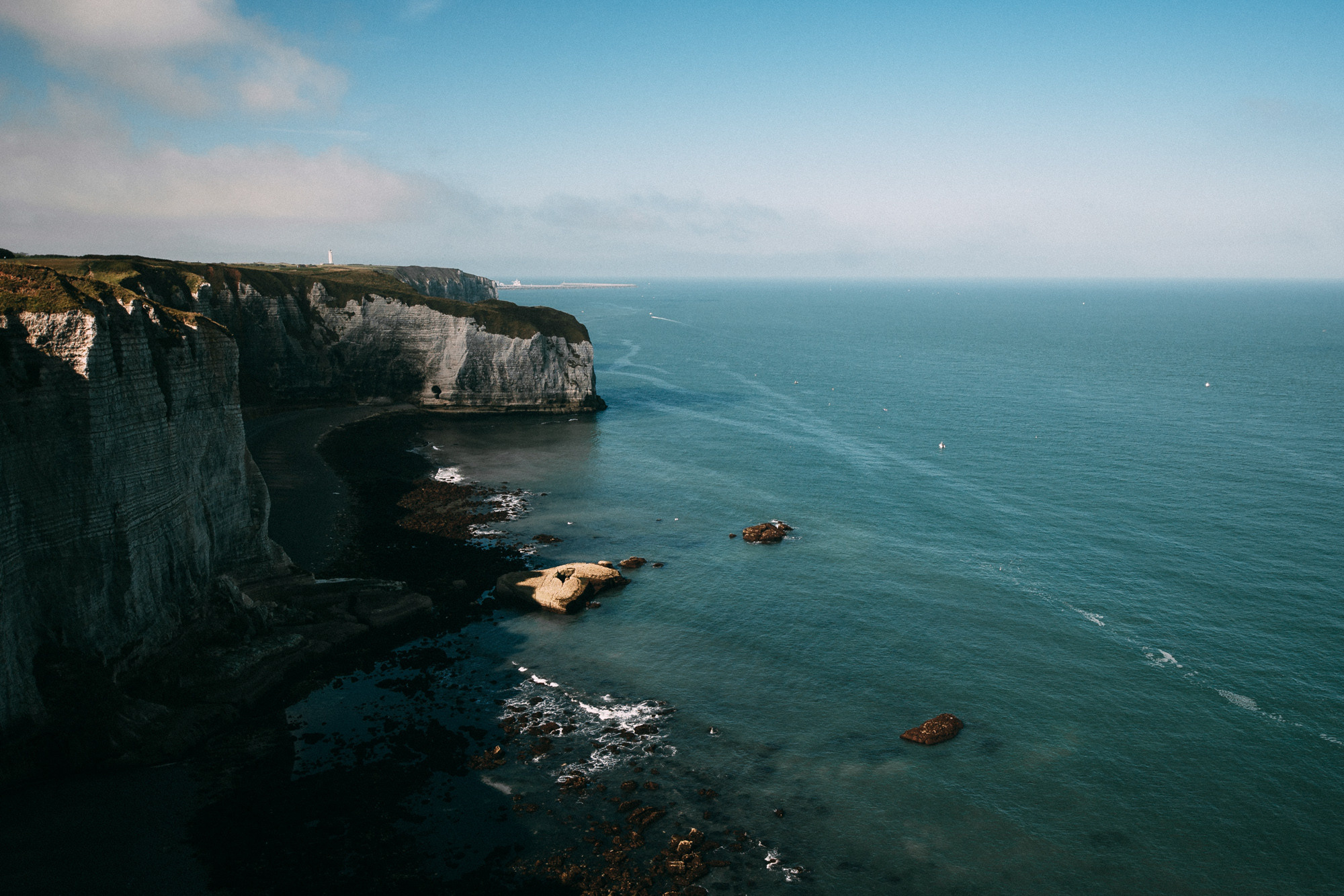 a view of a rocky coastline with a lighthouse