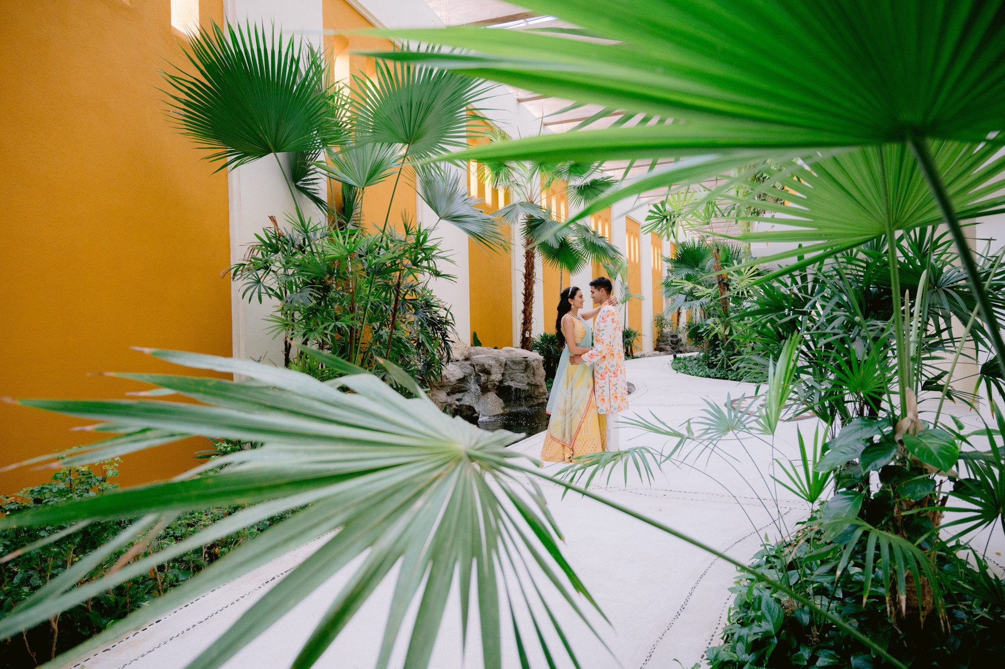 a woman in a yellow dress standing in a courtyard