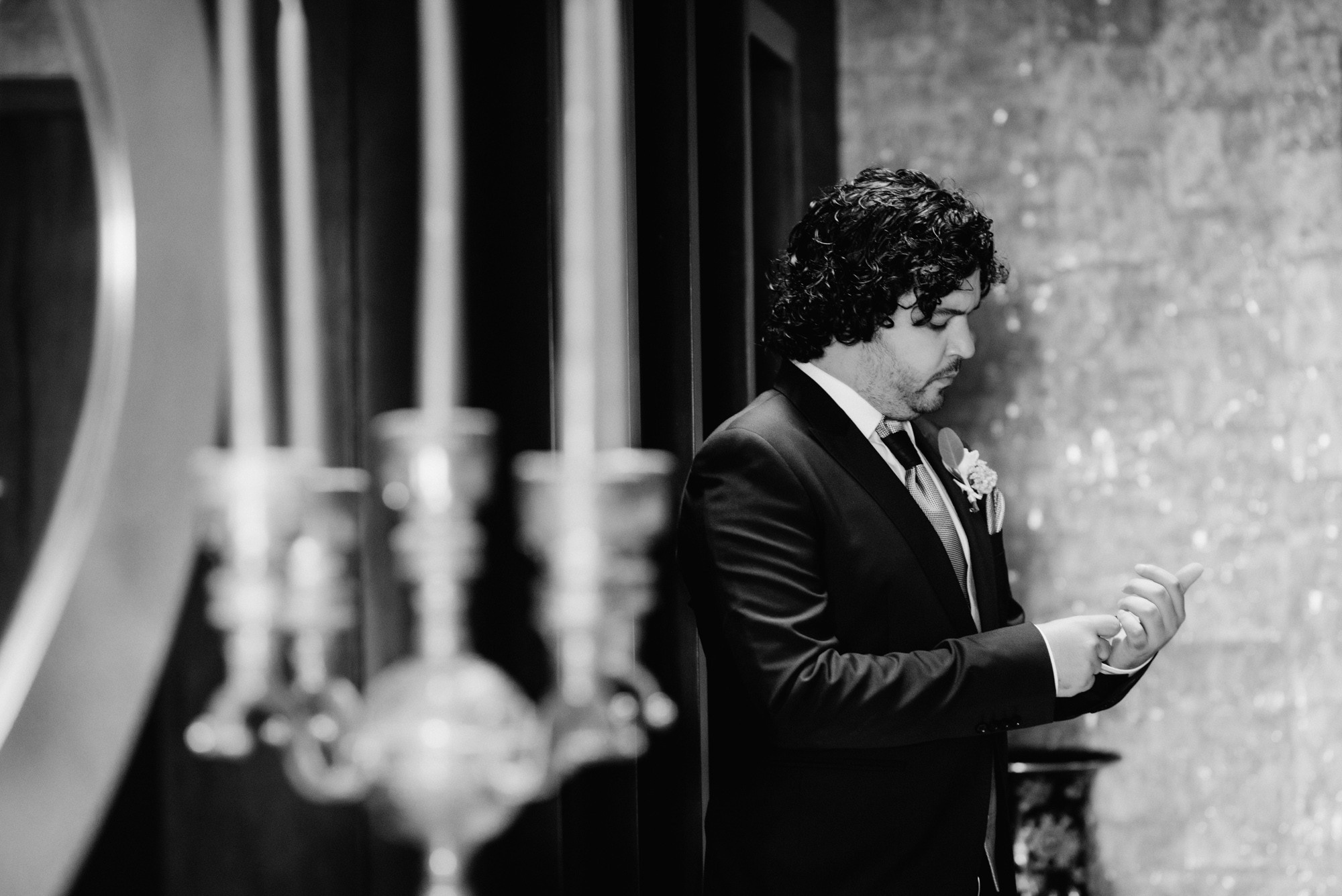 a man in a suit and tie standing next to a wall
