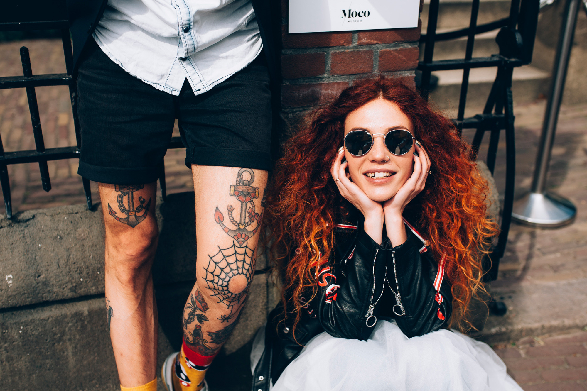 a woman with red hair and a tattoo on her arm