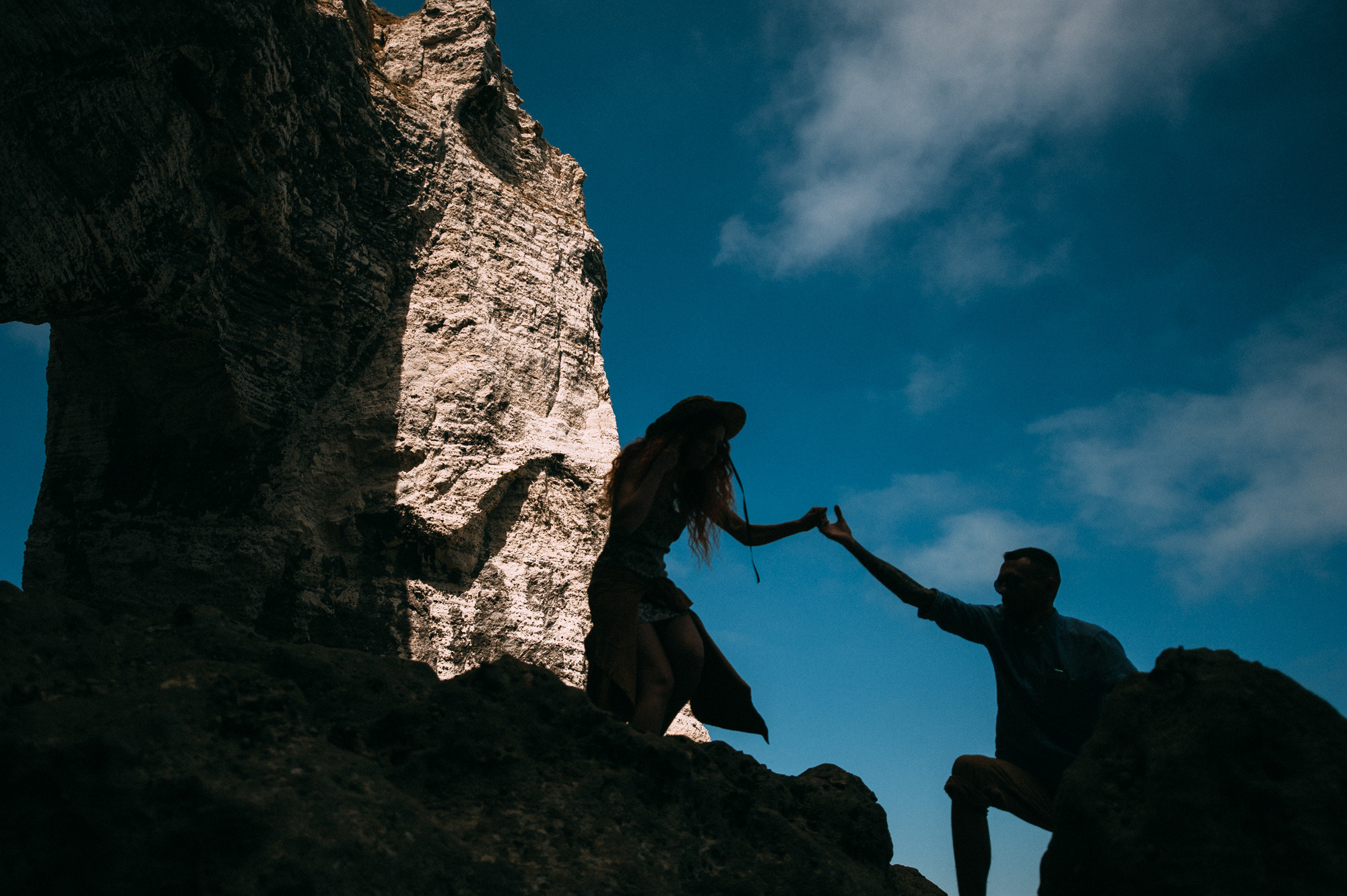 a man and woman are climbing up a mountain