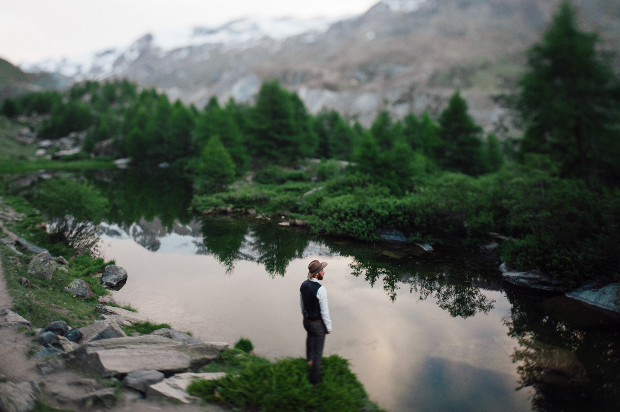 a man standing on a rocky shore next to a river