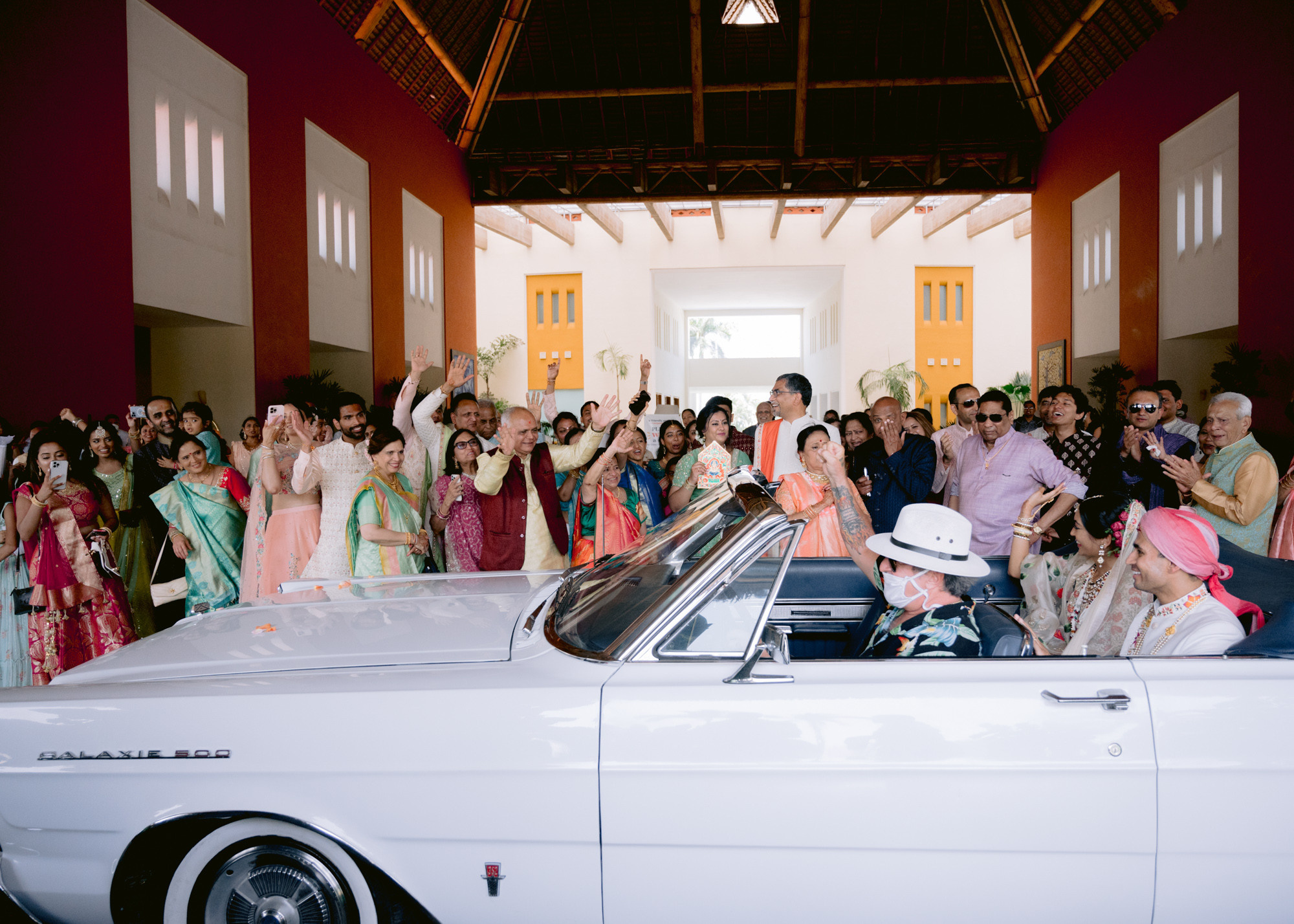 a group of people standing around a white car