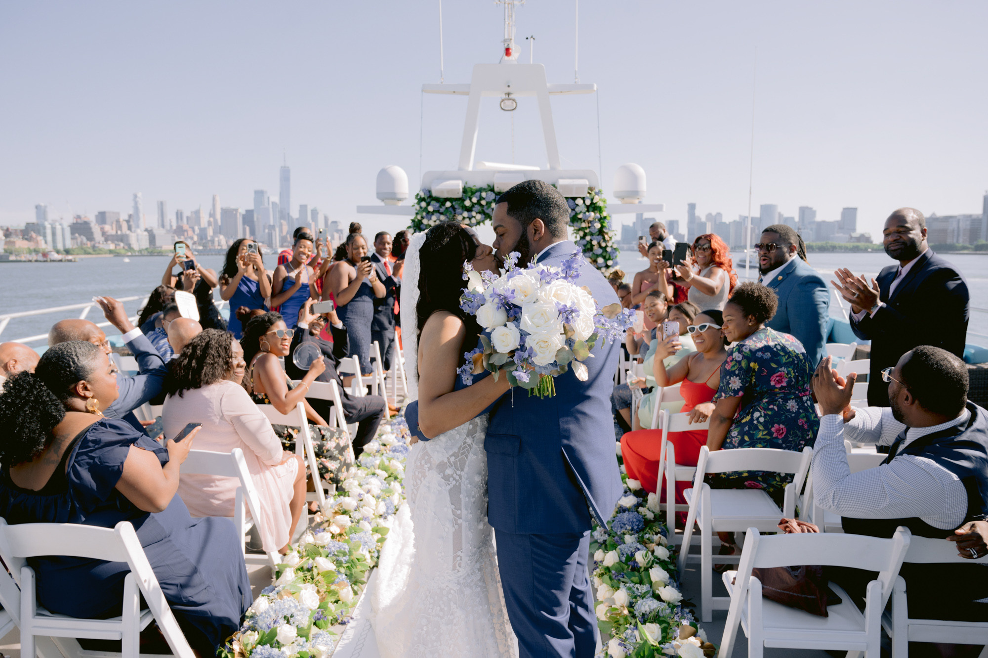 a bride and groom kiss as they walk down the aisle
