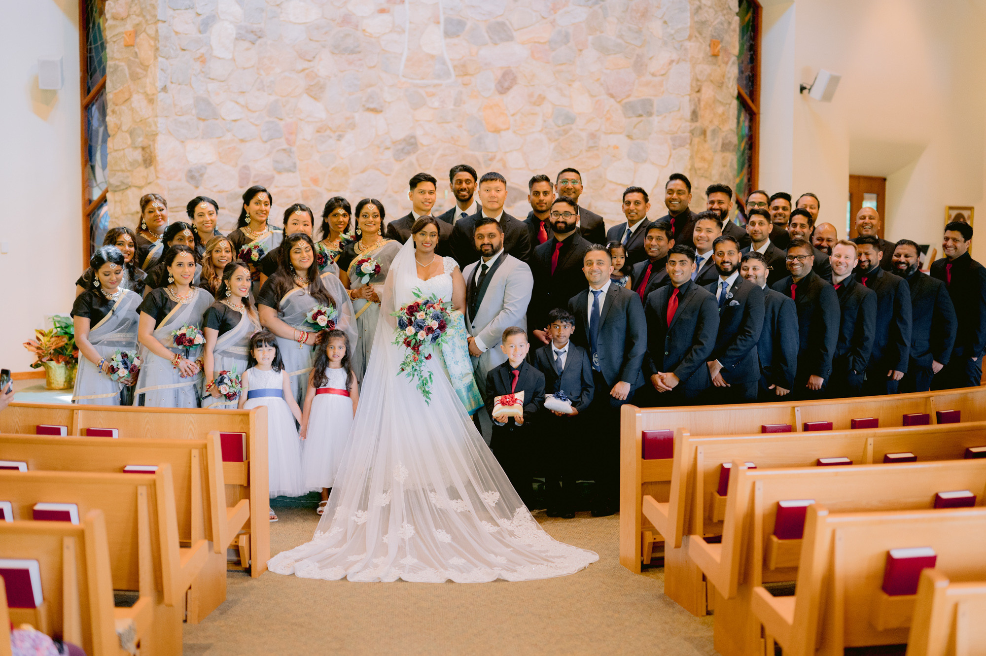 a wedding party poses for a photo in a church