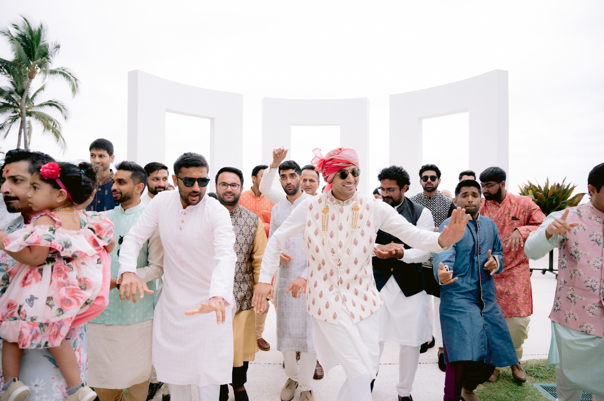 a group of people standing around a man in a white suit