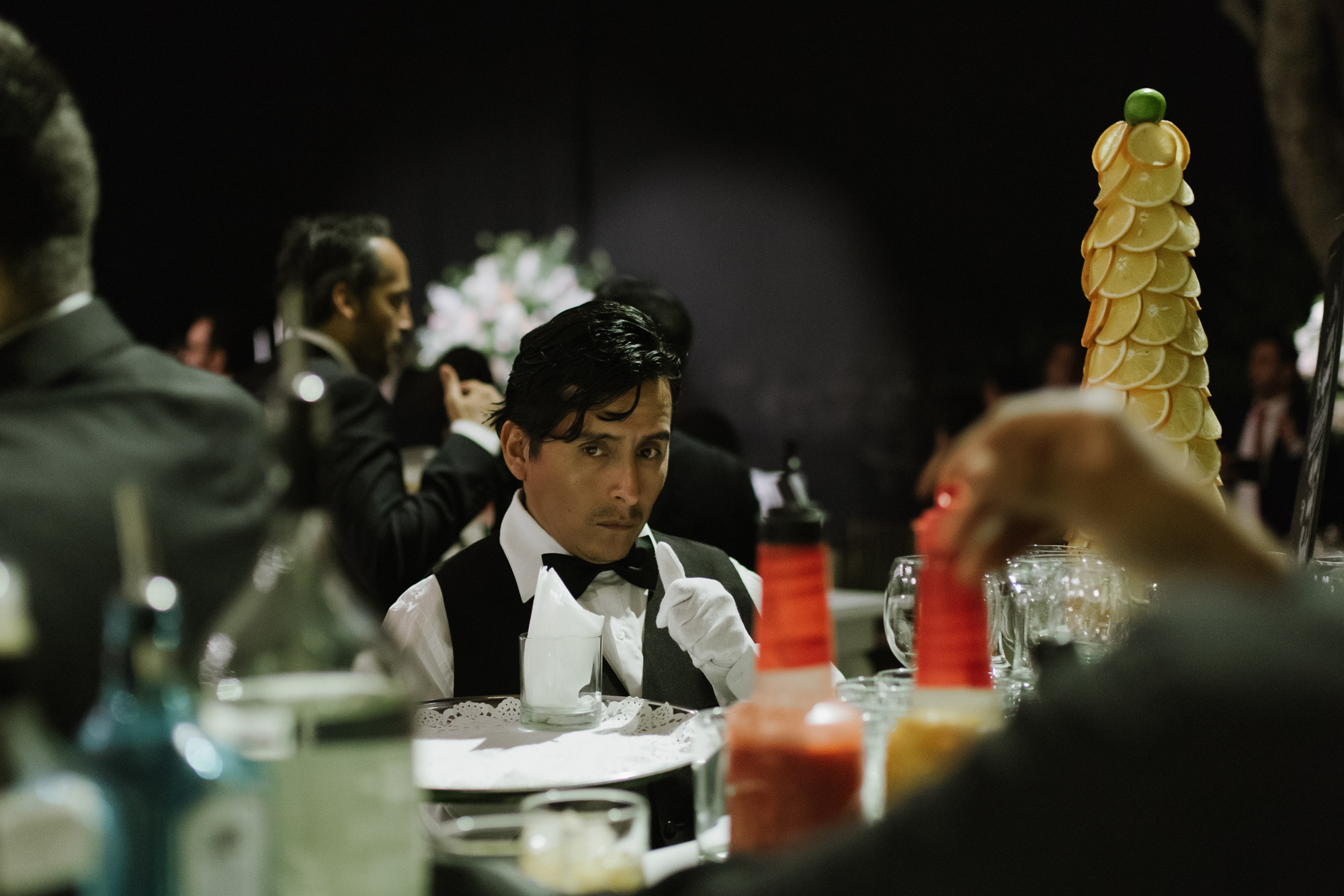 a man in a tuxed suit sitting at a table