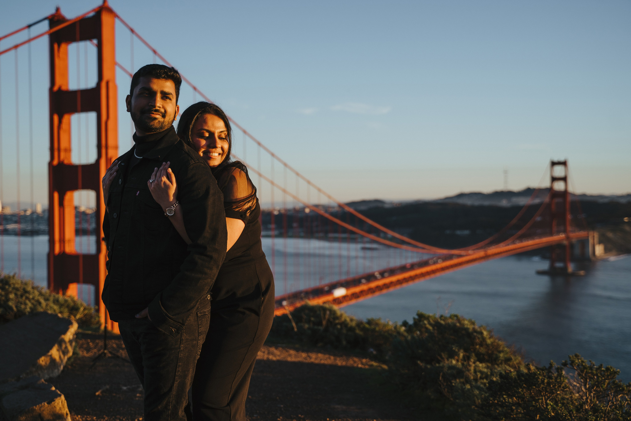 Proposal.  Overlooking the golden San Franisco Bridge sunset with a couple. Photographer Video. 