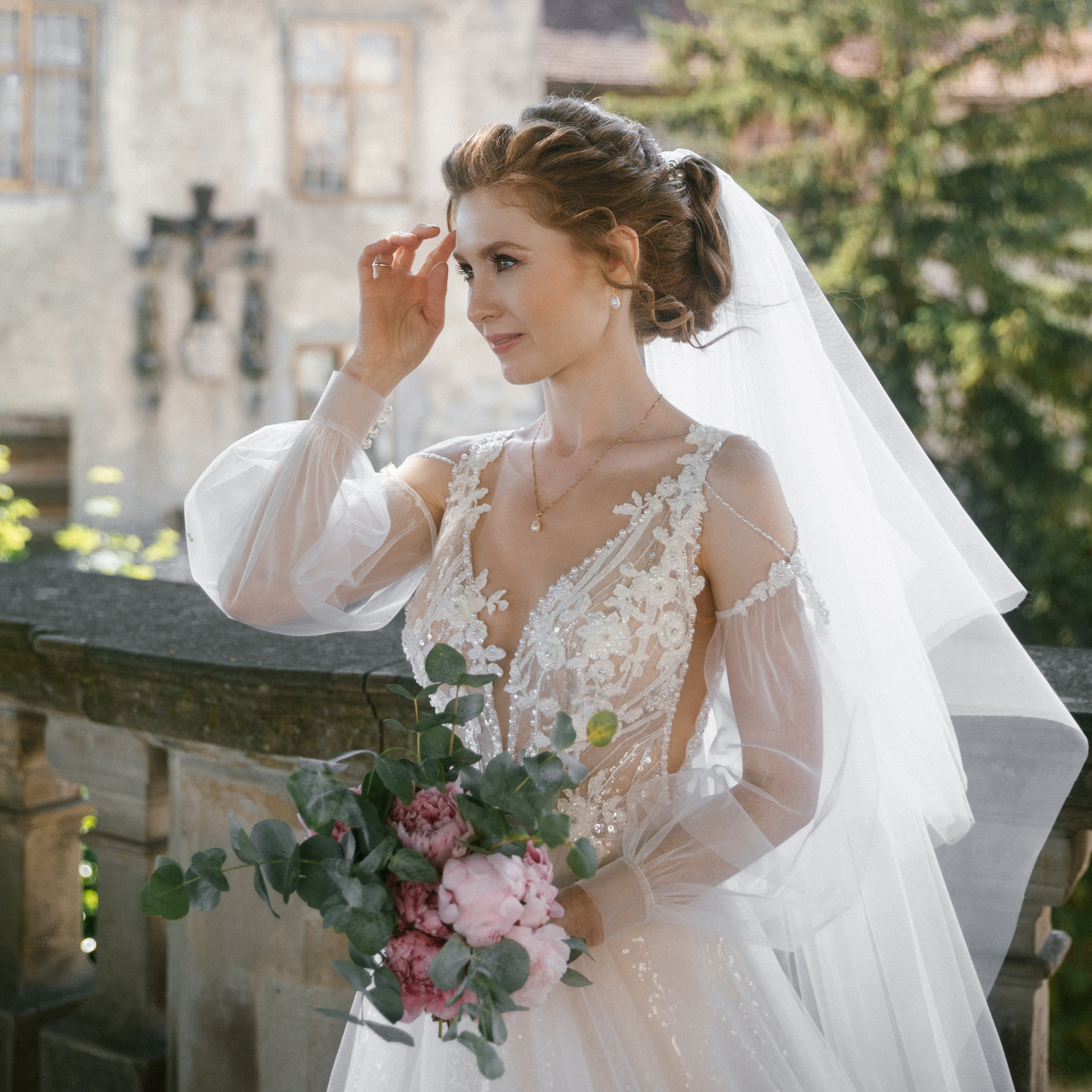 Bride with peony bouquet standing on sunlit terrace at Schloss Meersburg