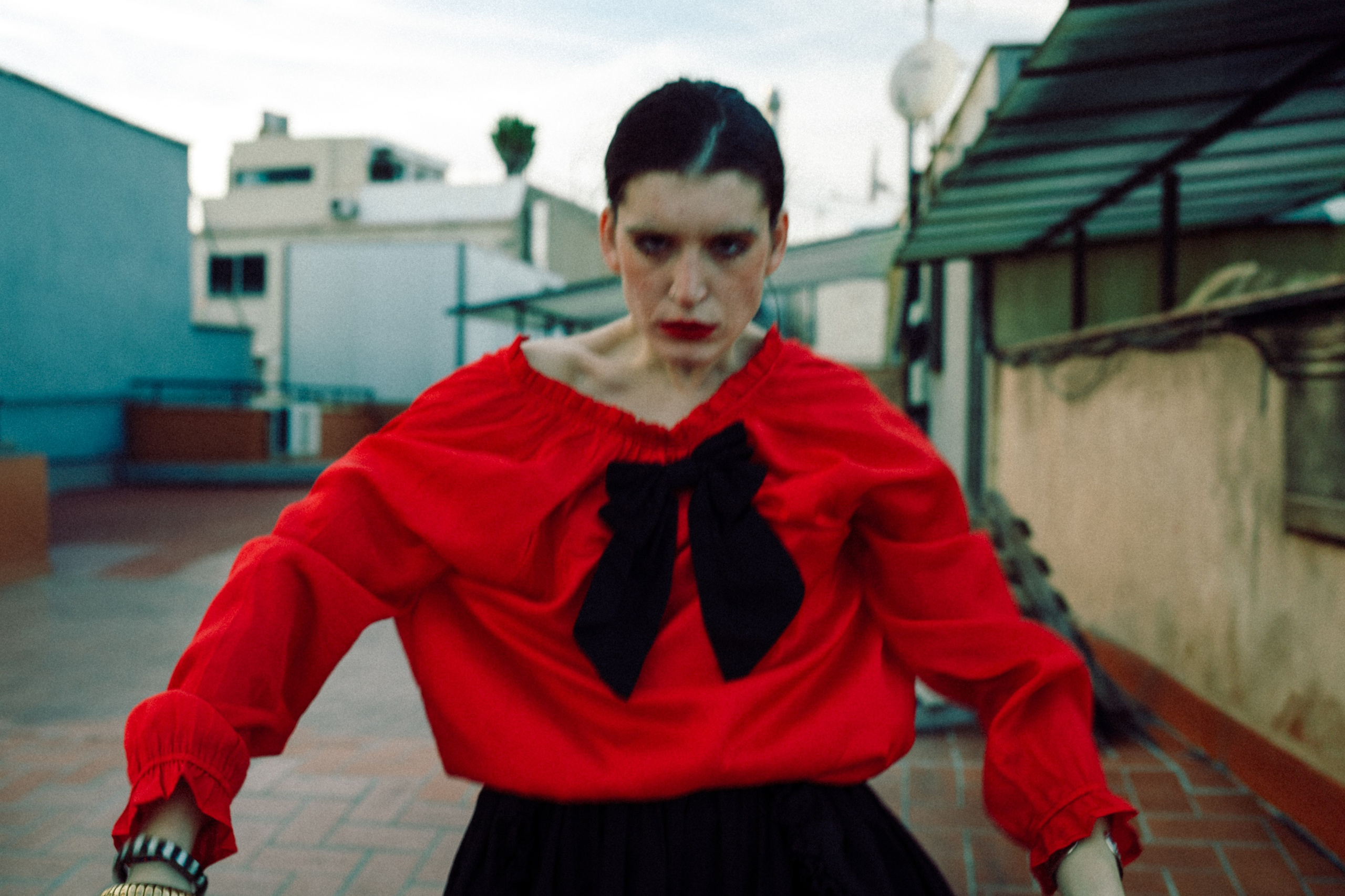 Woman in red top staring intensely at the camera