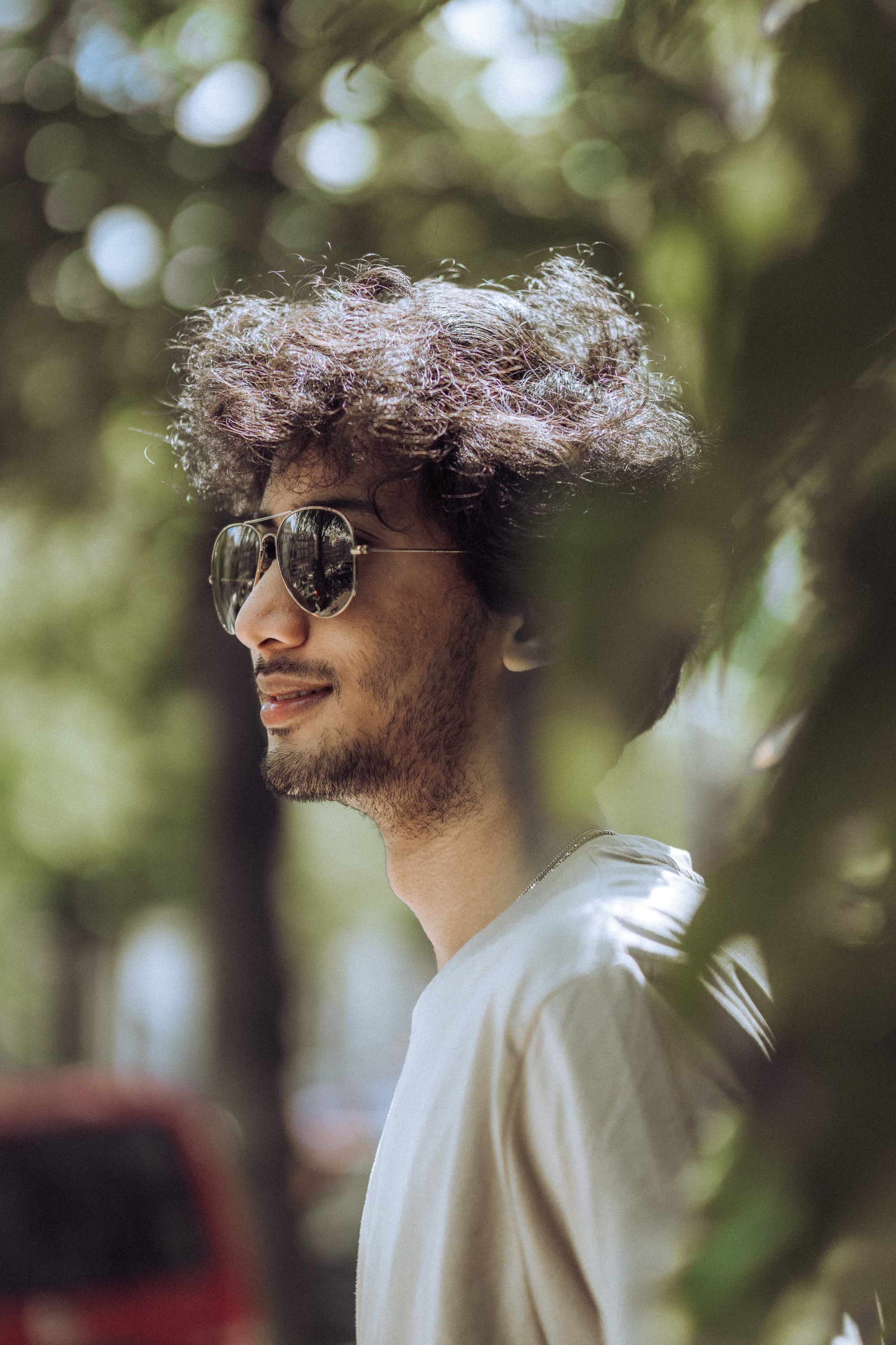 a man standing near a climbing bush wearing sunglasses in amsterdam