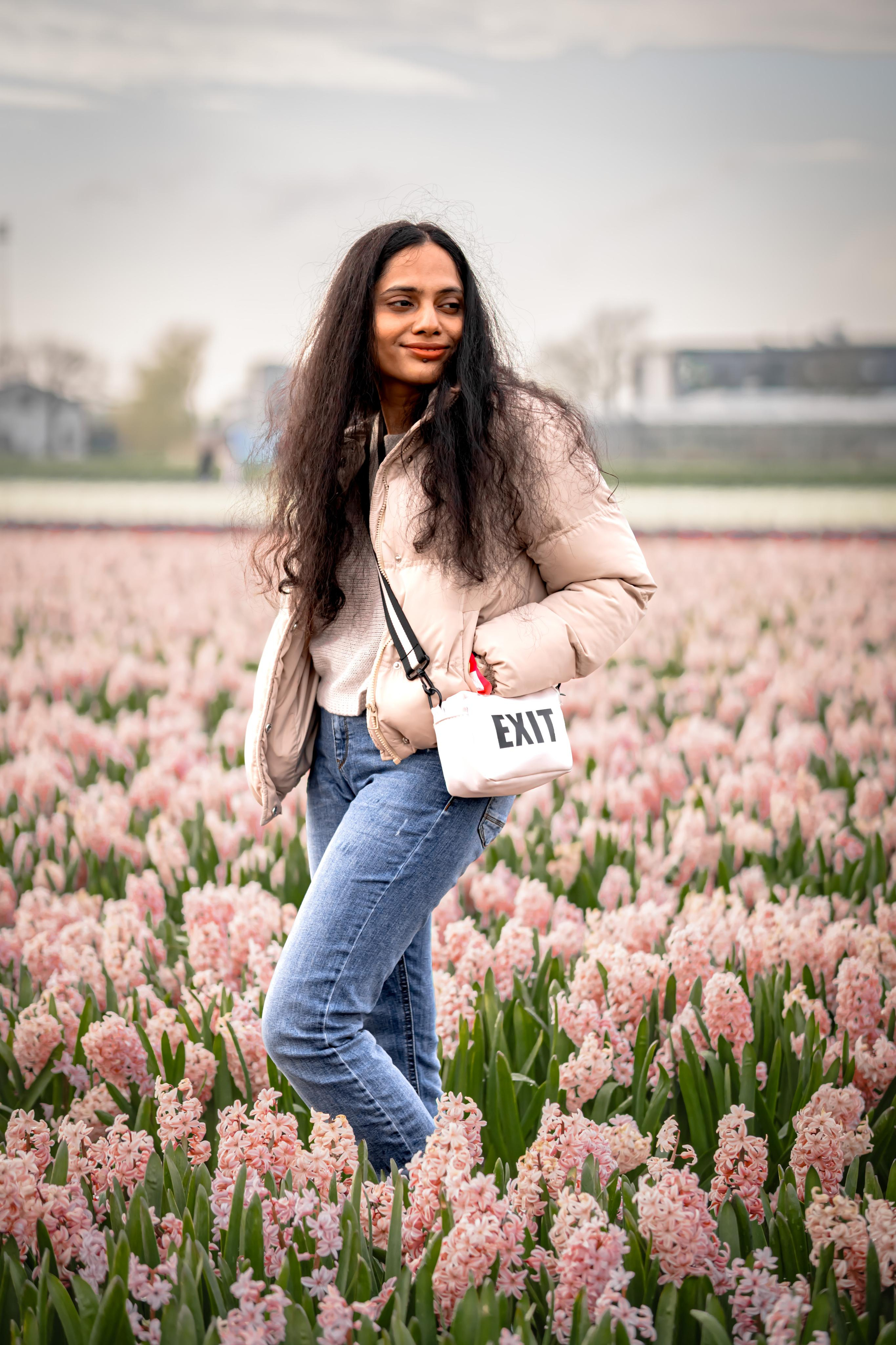 girl standing in a pink hyacinth fields in Netherlands