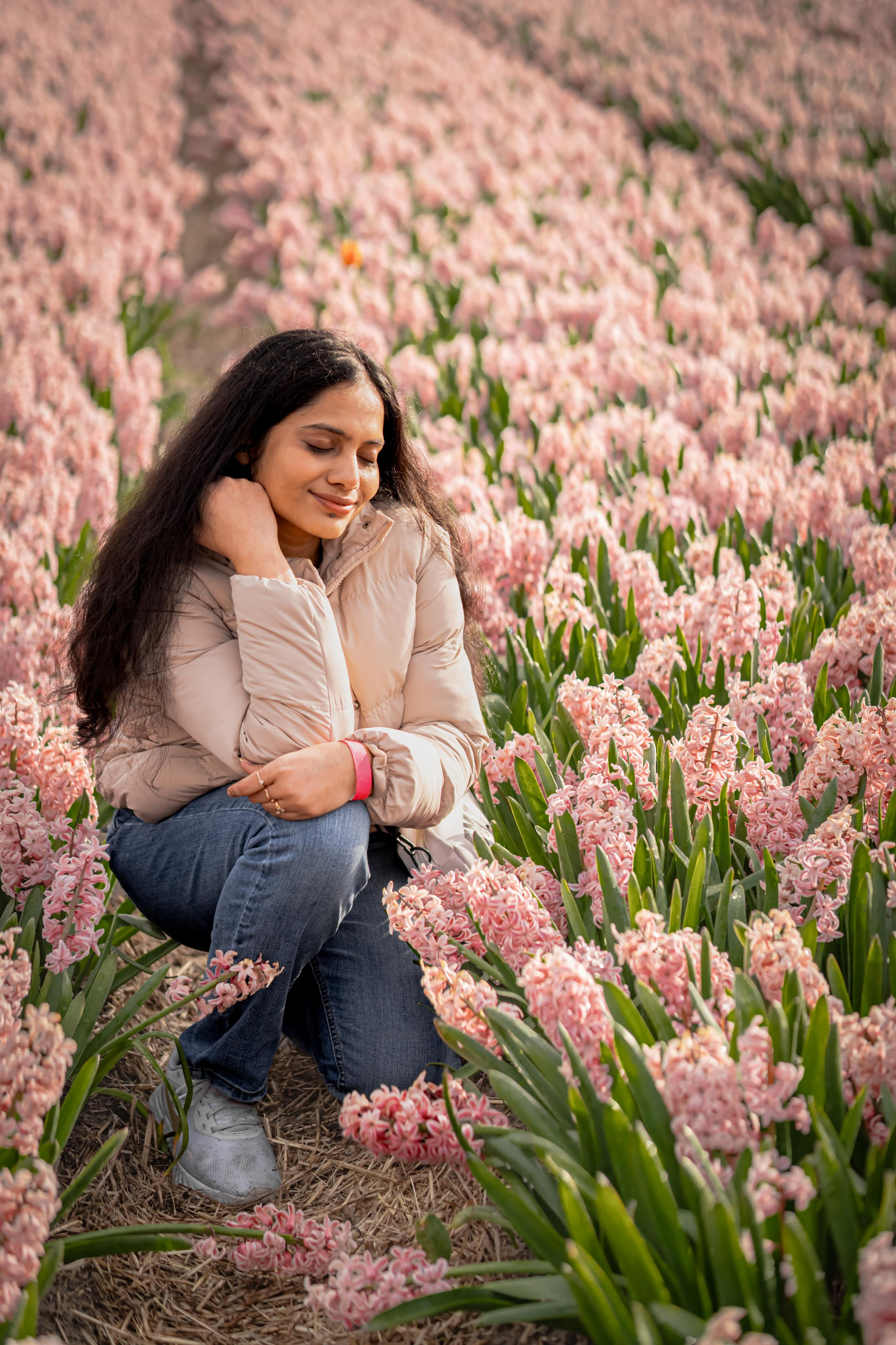 girl sitting in a pink hyacinth fields in Netherlands