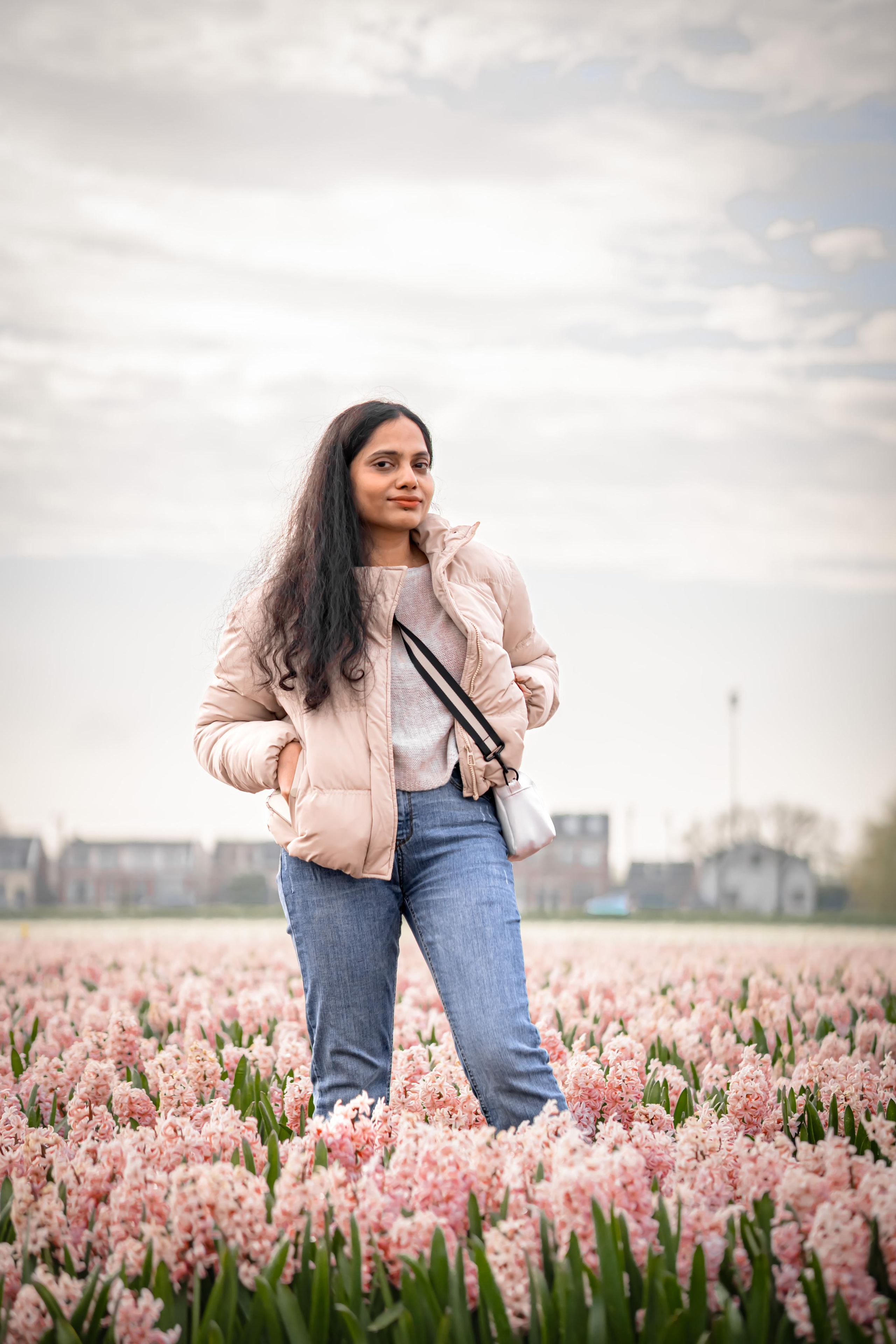 girl standing in a pink hyacinth fields in Netherlands