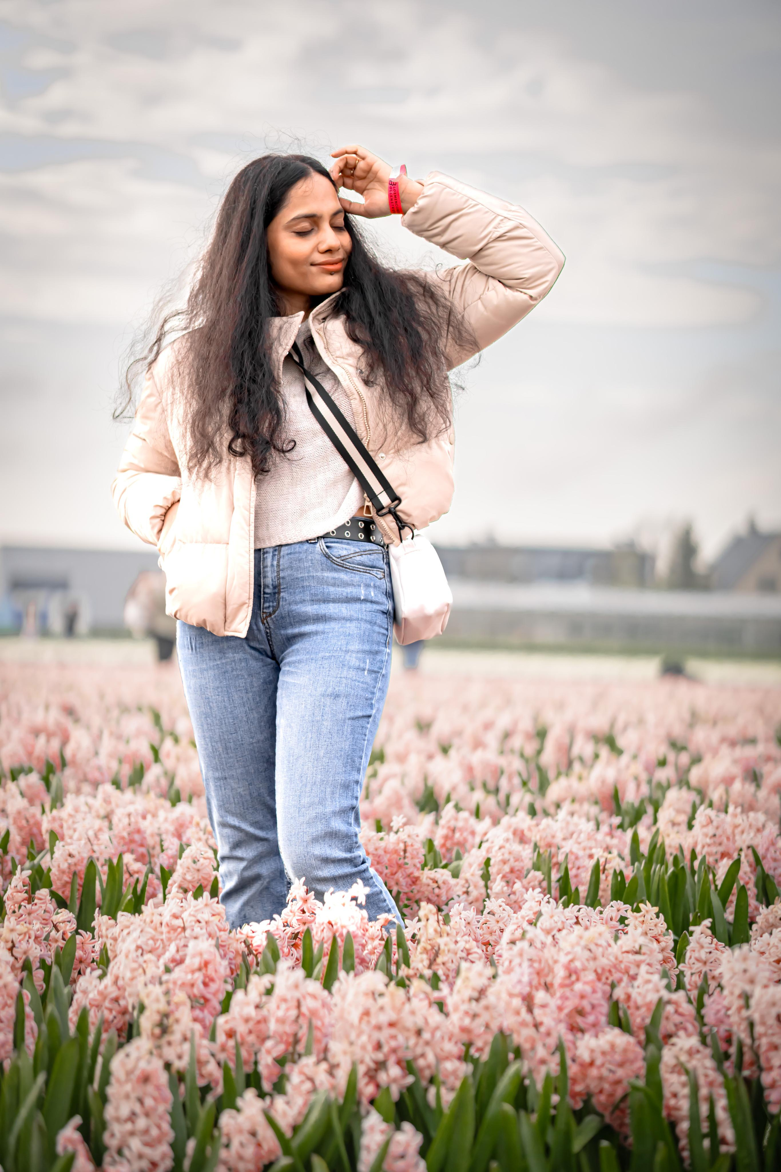 girl standing in a pink hyacinth fields in Netherlands