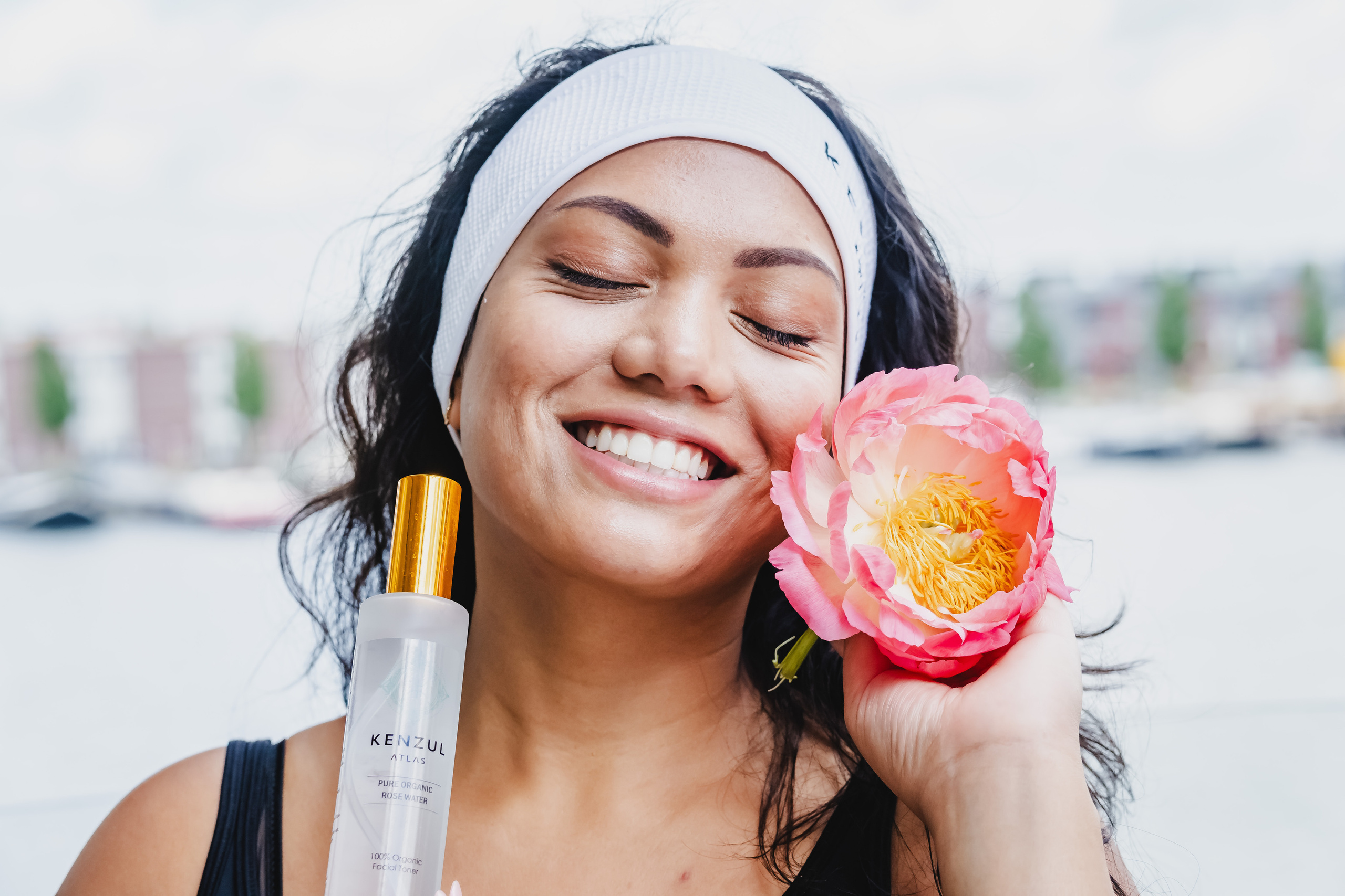 girl holding a white transparent bottle and a red flower