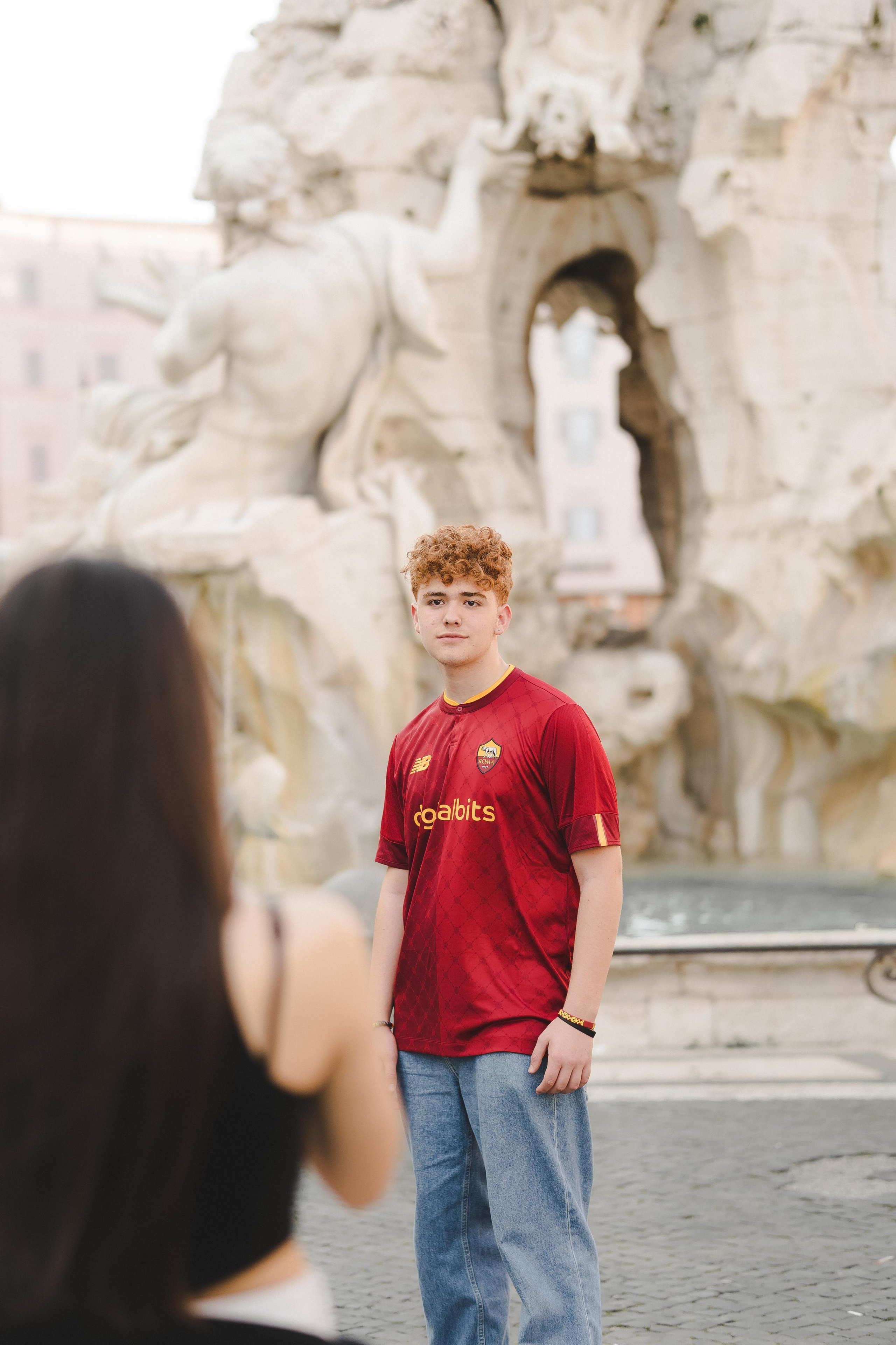 A girl looking at aboy wearing a red jersey