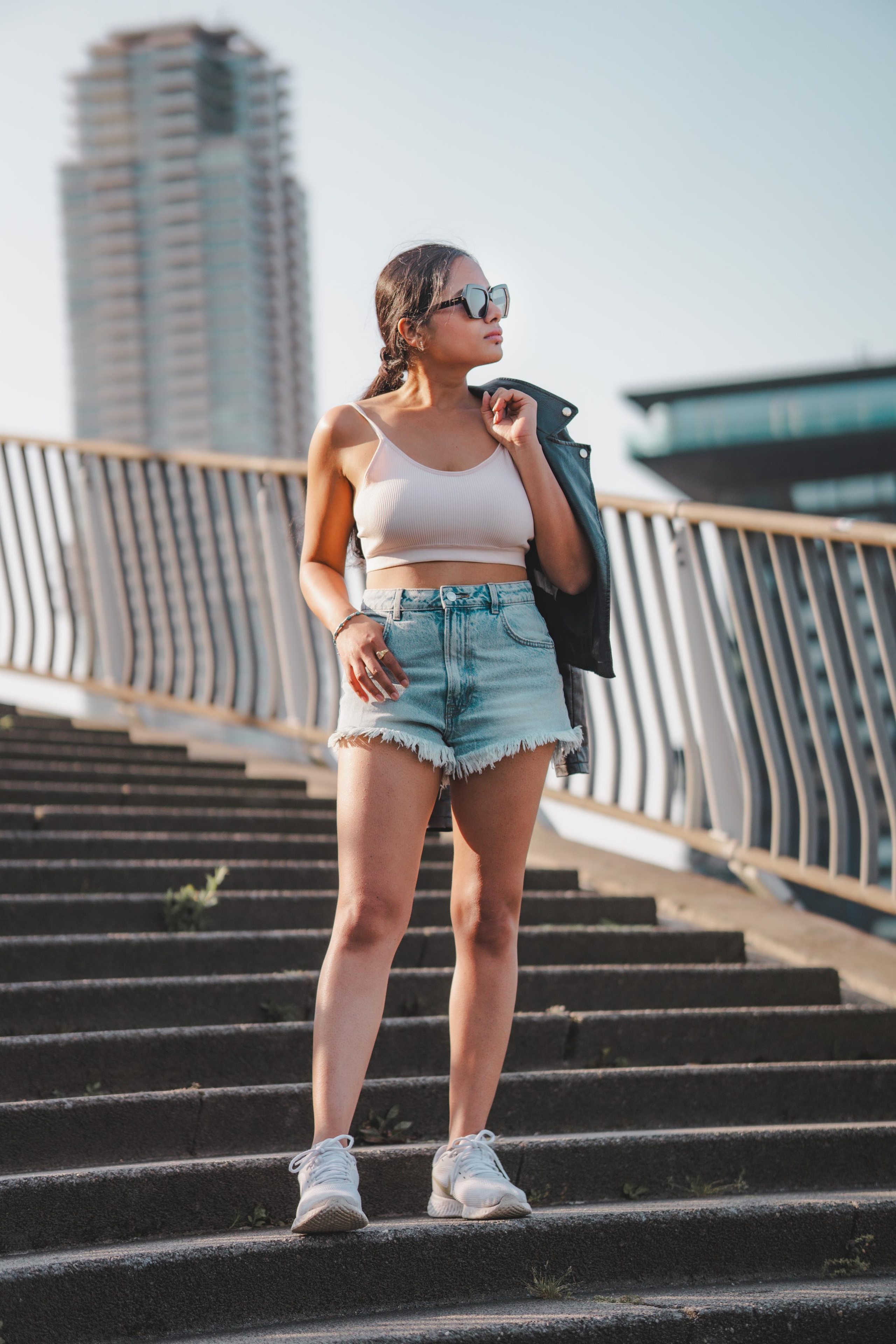 A woman standing on a staircase in rotterdam and holding her black leather jacket
