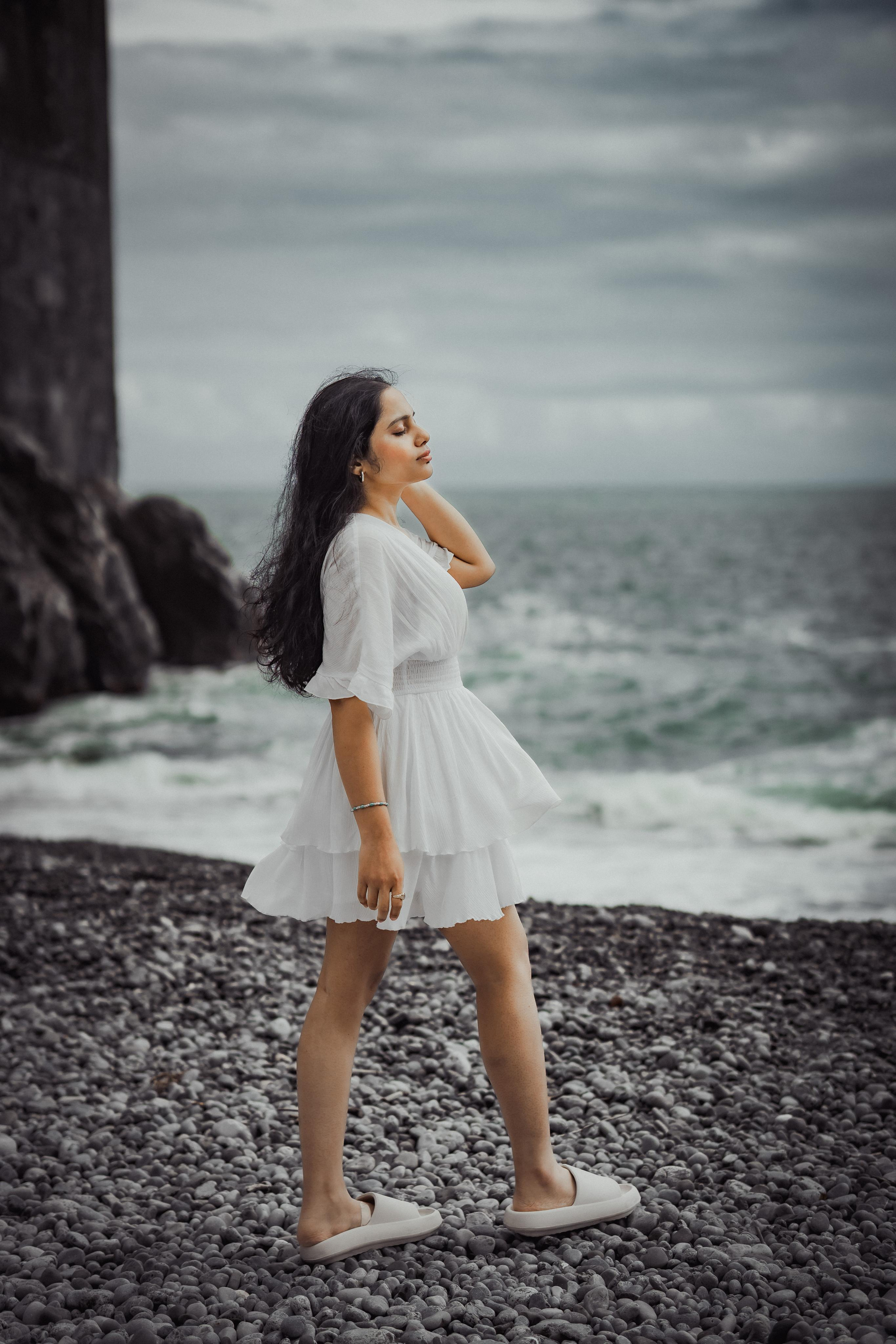 a woman wearing a white beach dress and enjoying the sea view in amalfi coast