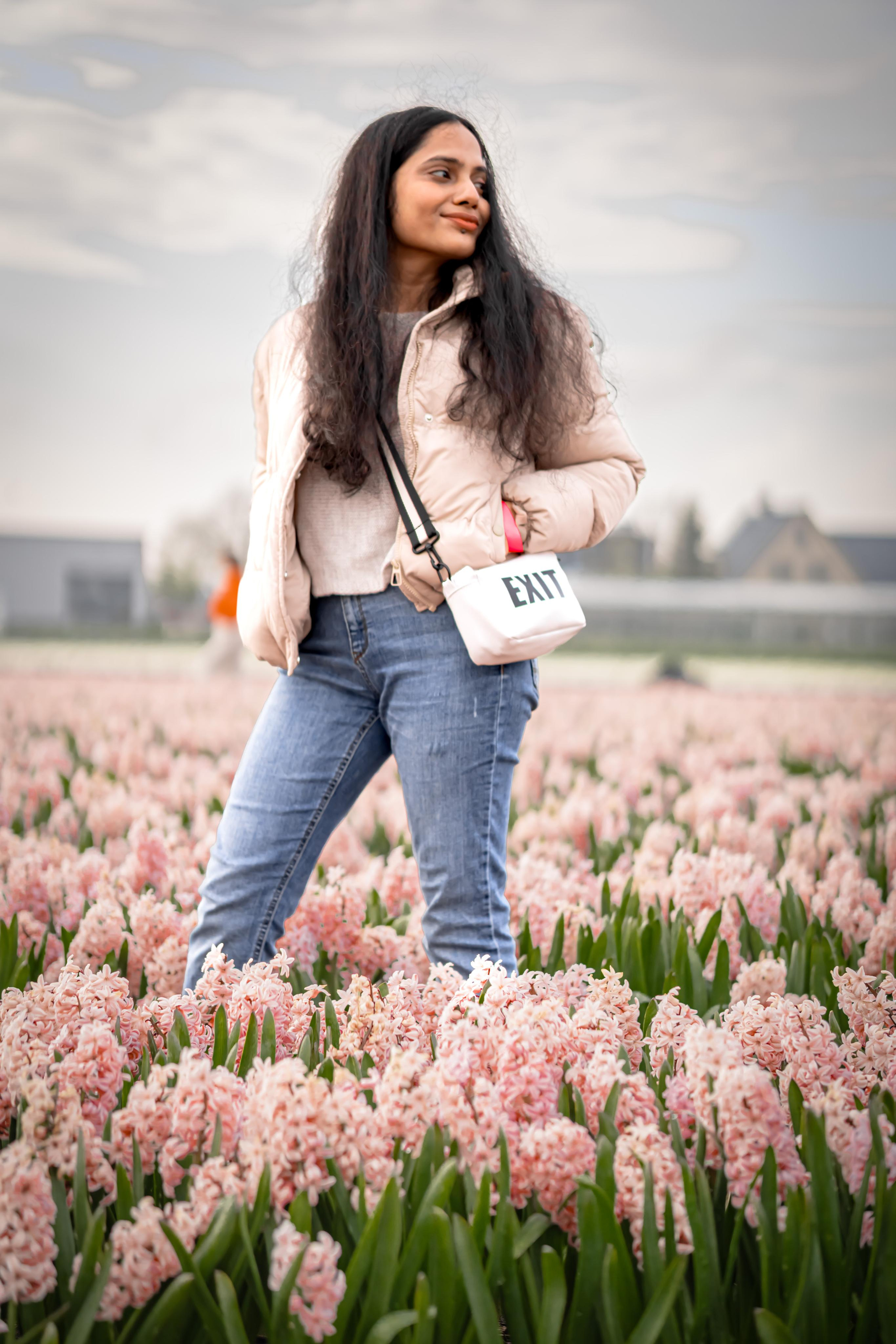 girl standing in a pink hyacinth fields in Netherlands