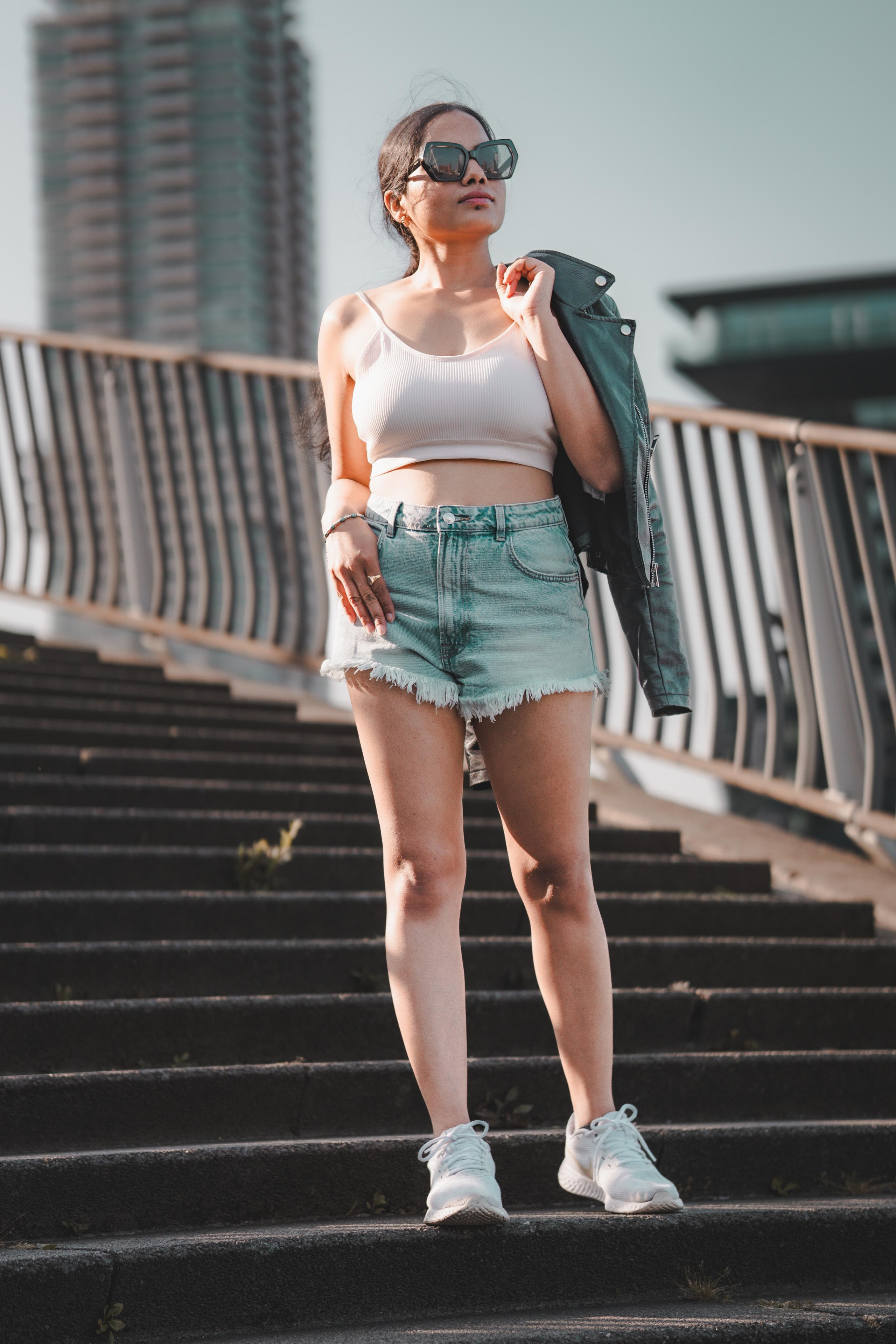 A woman standing on a staircase in rotterdam and holding her black leather jacket