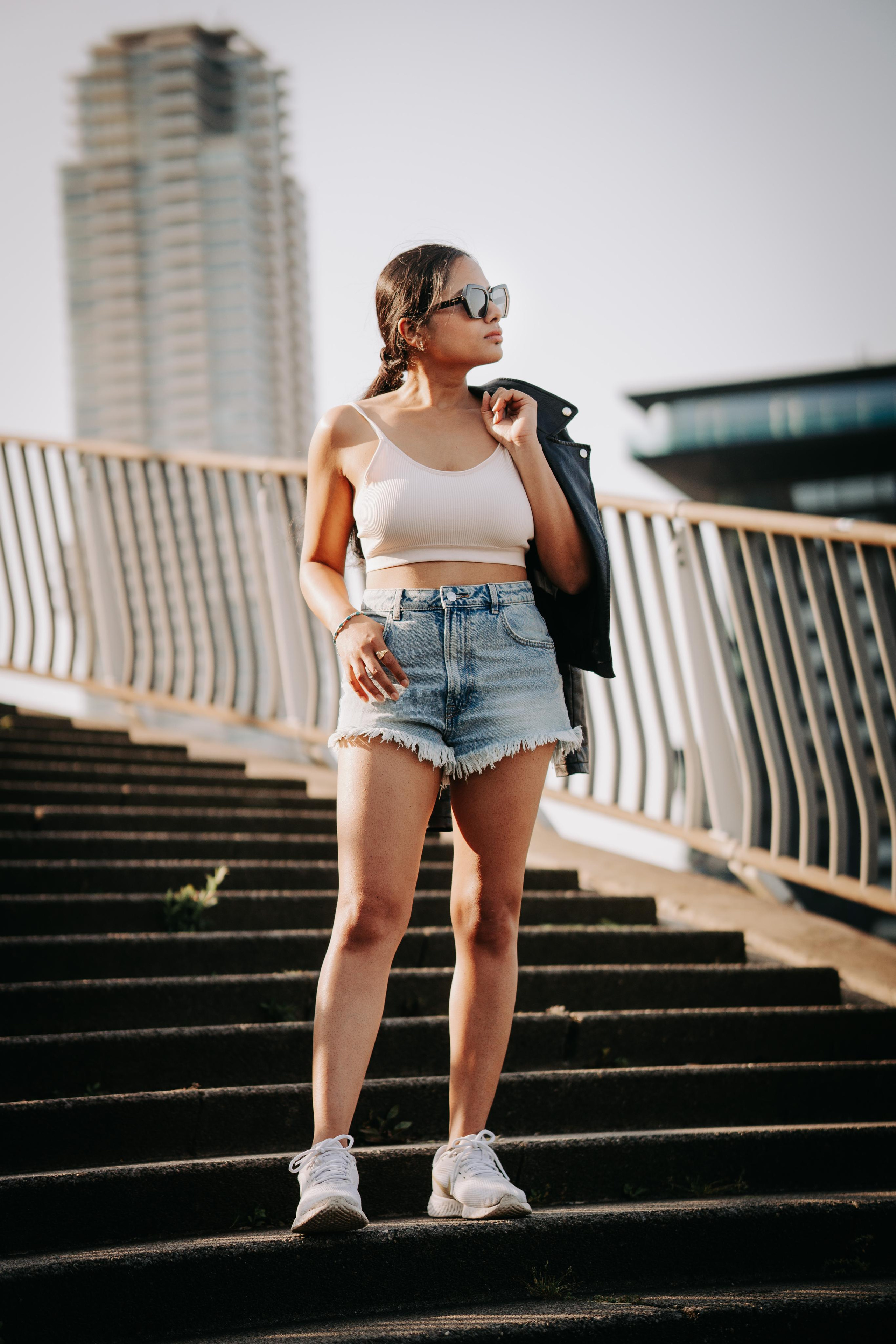 A woman standing on a staircase in rotterdam and holding her black leather jacket