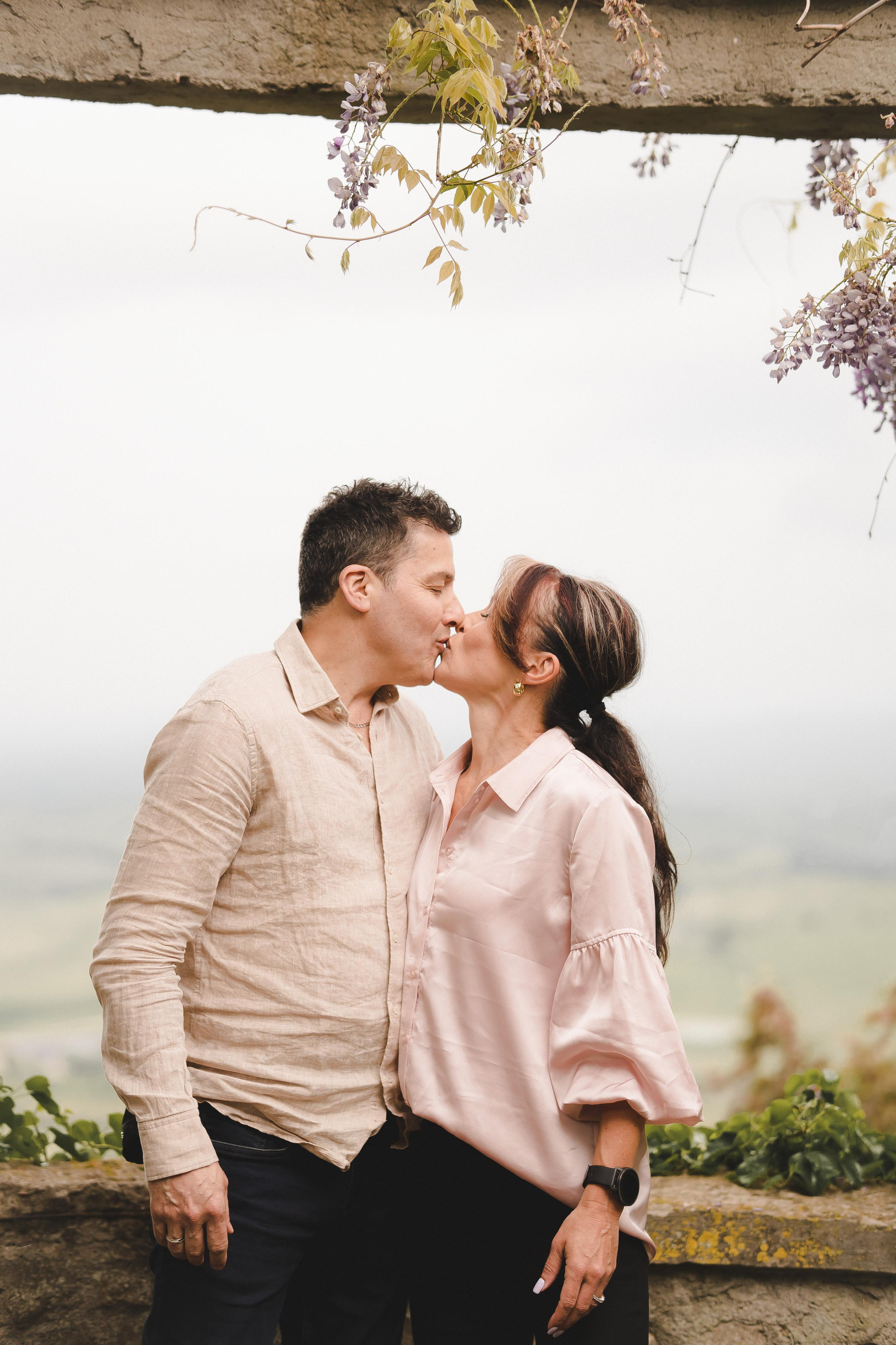 Lovely couple kissing at the edge of cliff in Tuscany