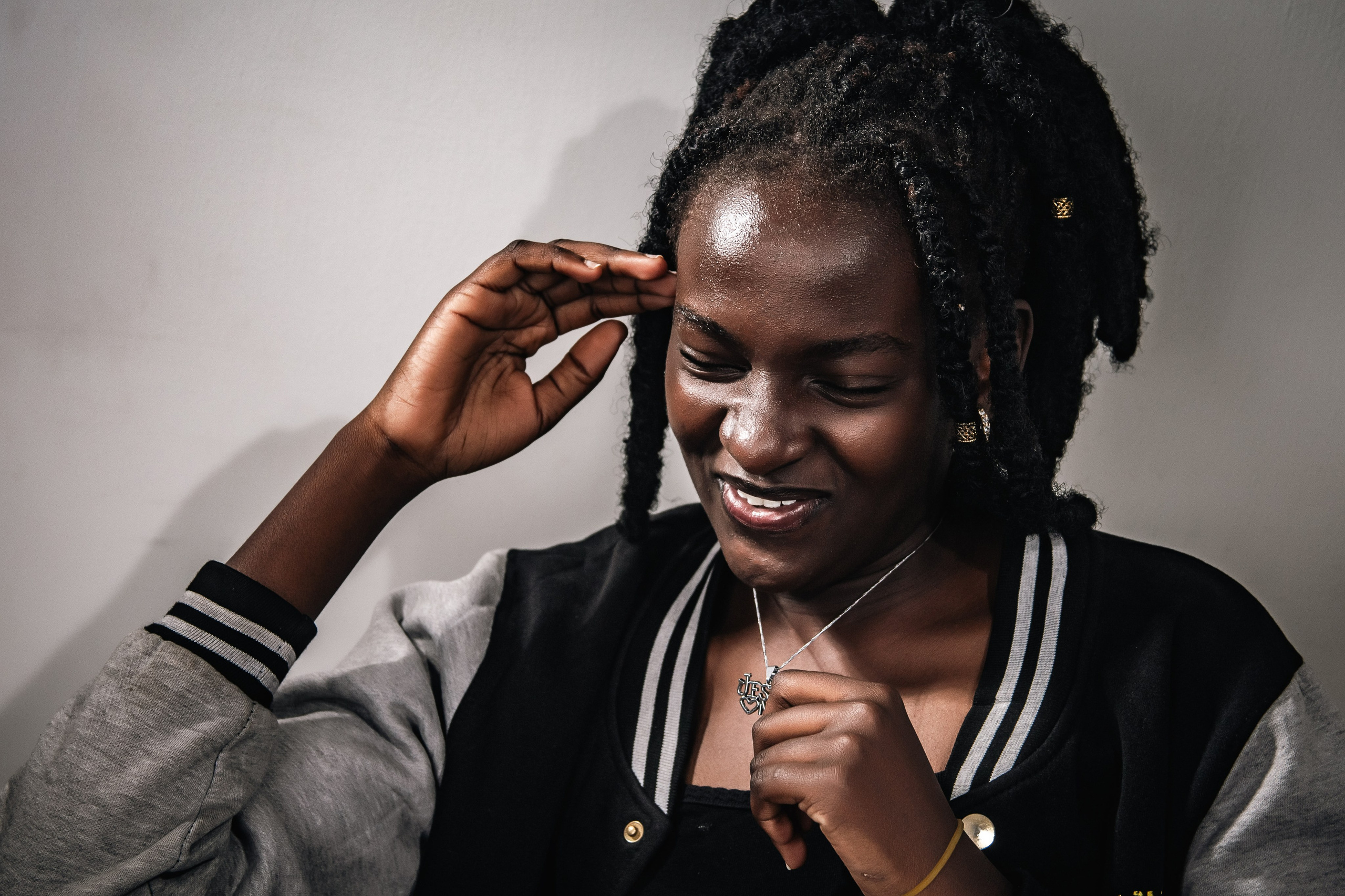 Laughing woman holding her pendant — lifestyle portrait by Nick Ouma Photography, Nairobi, Kenya