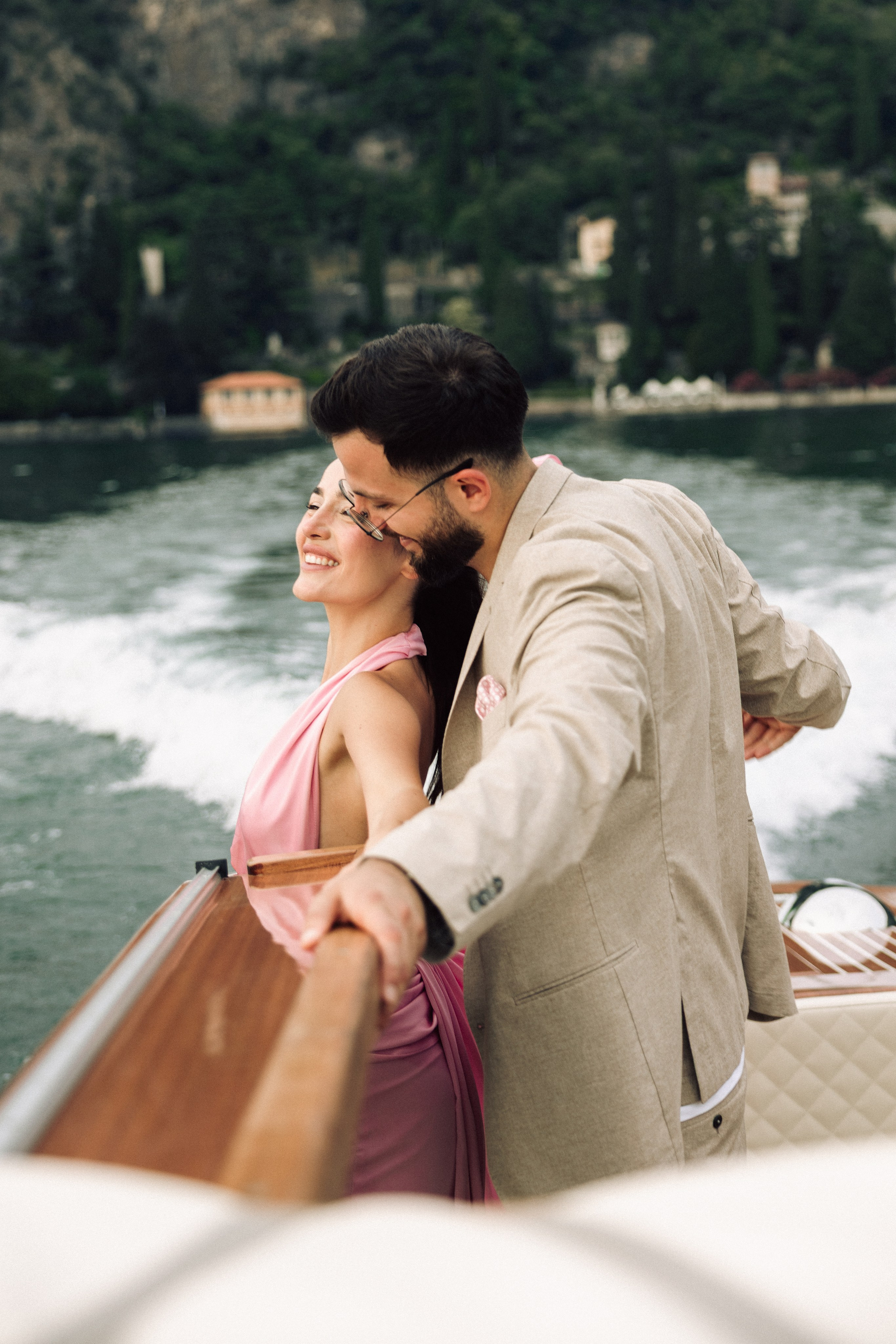Couple embracing on a private boat during a romantic proposal on Lake Como