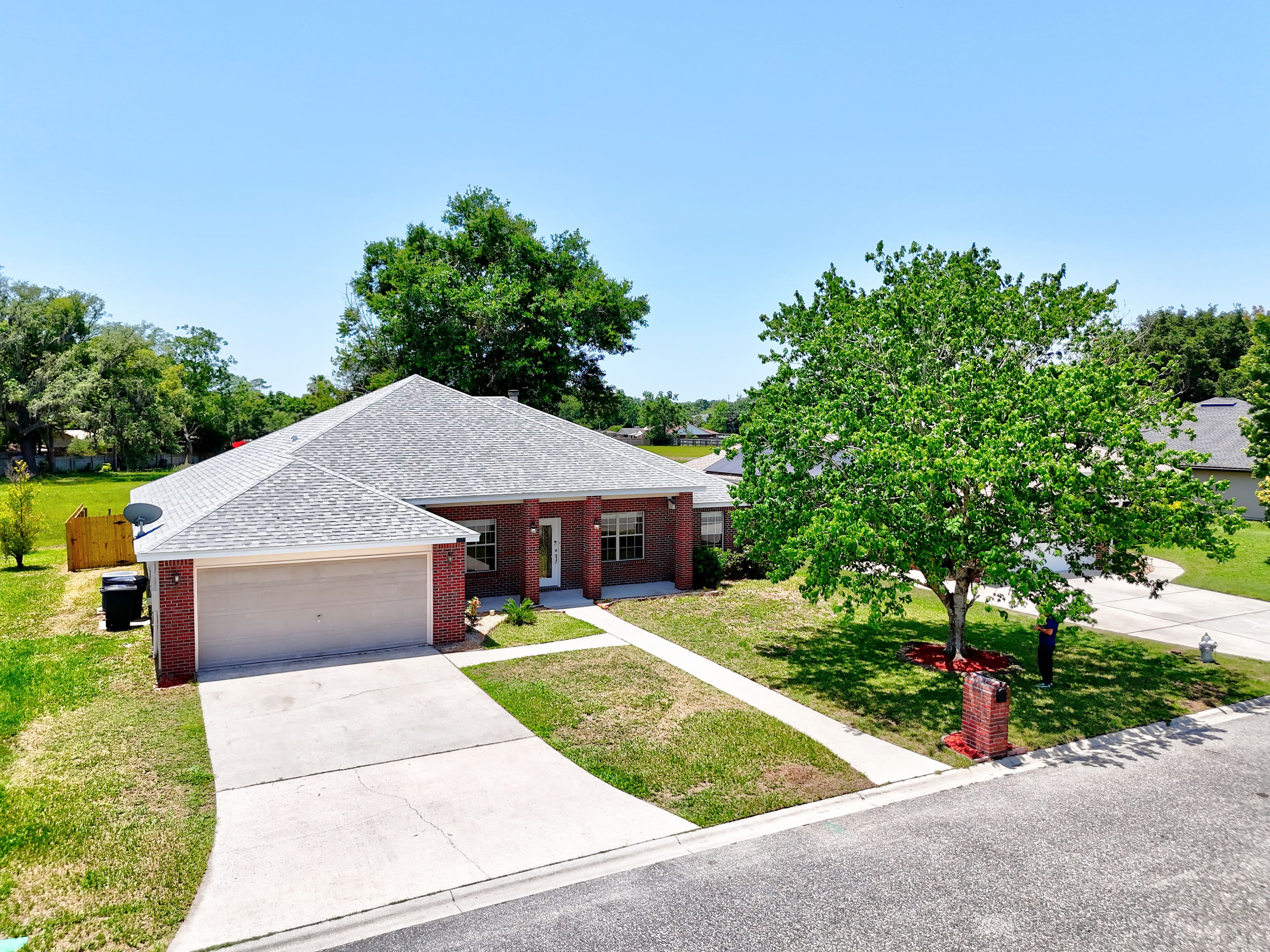 Modern brick single-story house with two-car garage and front yard tree