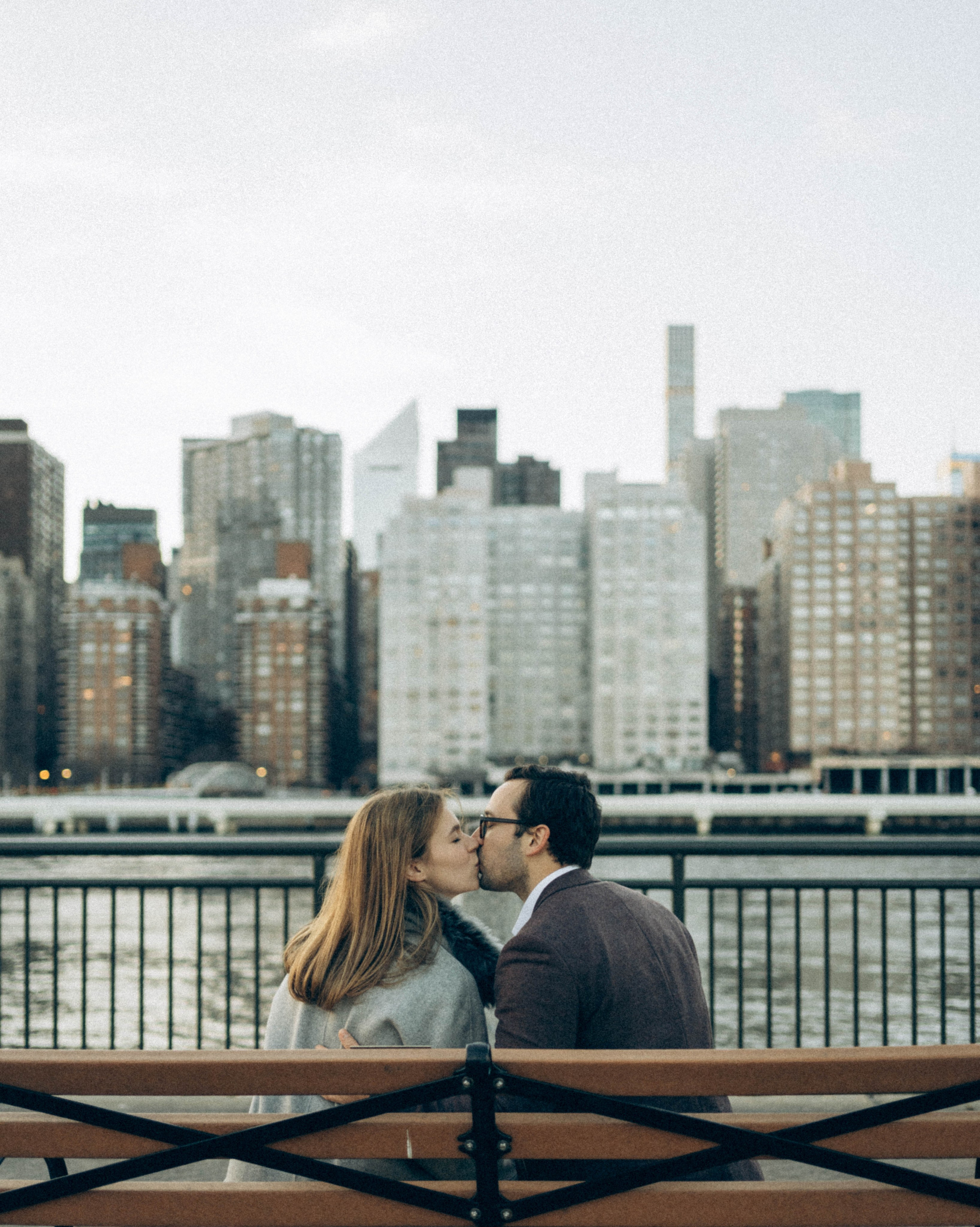 Man kneeling in Central Park winter path.