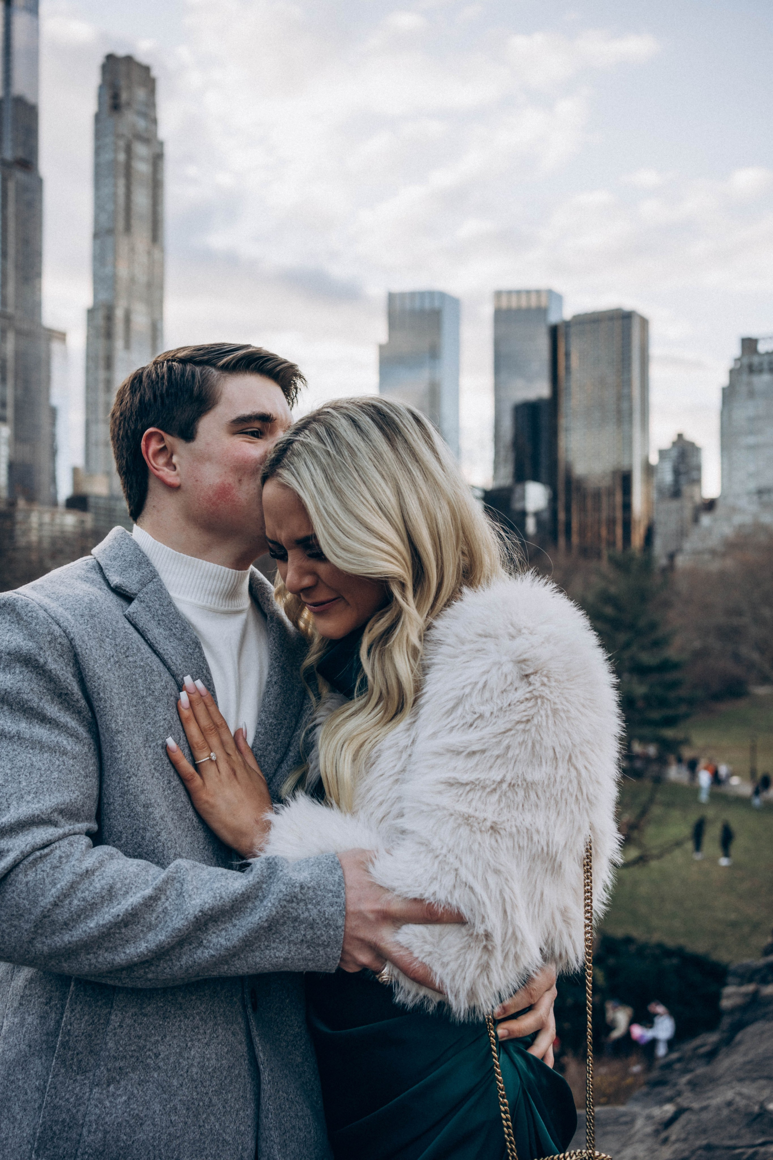 Joyful couple hugging with skyline view in Dumbo.