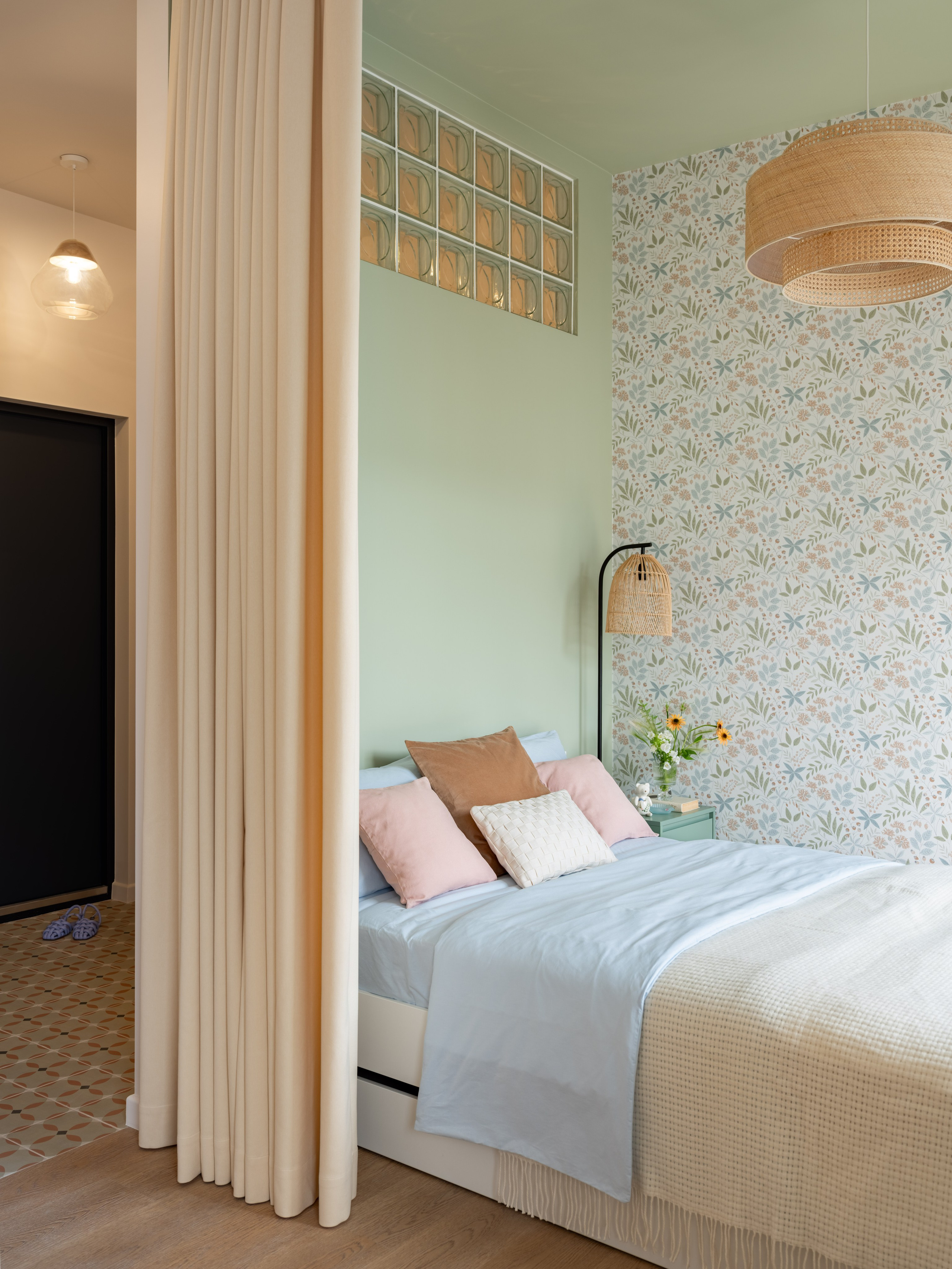 Интерьер с цветочными обоями и стеной из стеклоблоков.