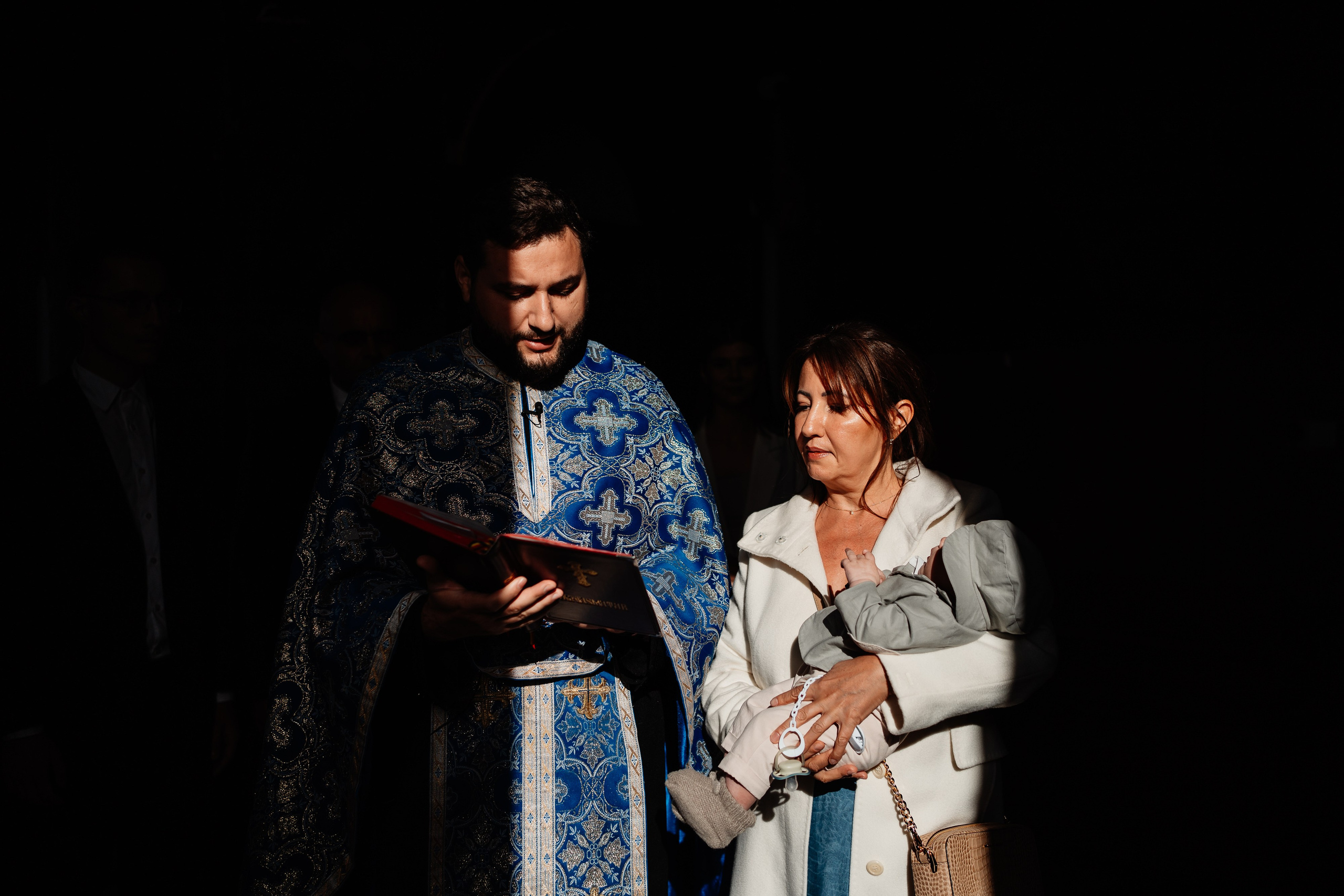 Instantaneu plin de tandrețe dintre părinți și bebeluș în ziua botezului, realizat în Craiova. Fotografie profesională de botez, capturând emoțiile autentice ale familiei într-un decor luminos și cald